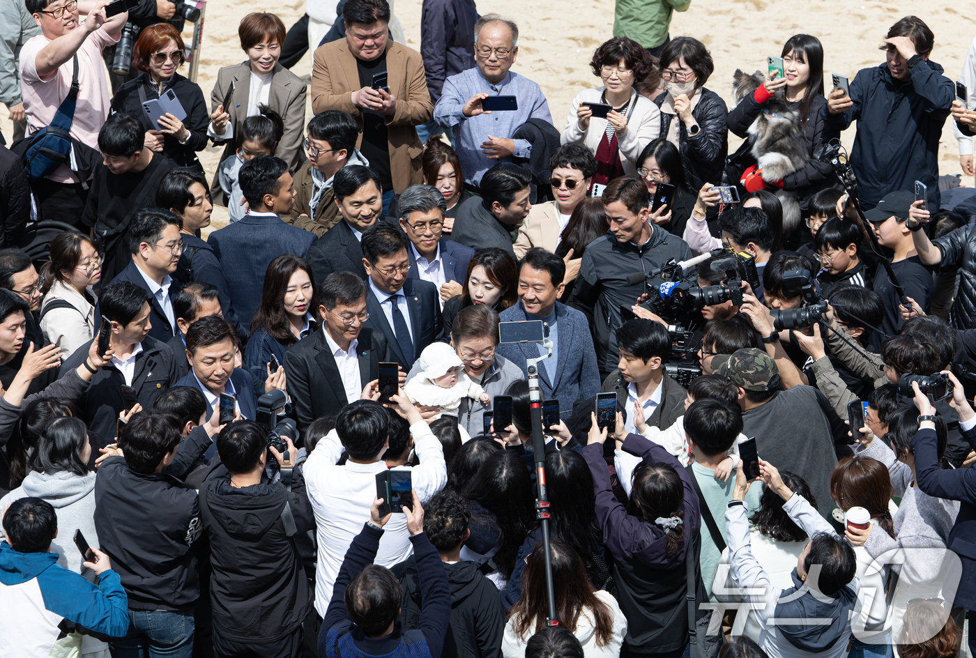 (강릉=뉴스1) 이재명 기자 = '골목골목 경청투어 : 동해안벨트편'에 나선 이재명 더불어민주당 대통령 후보가 3일 오후 강원 강릉시 안목해변에서 한 아이를 안고 있다. 2025. …