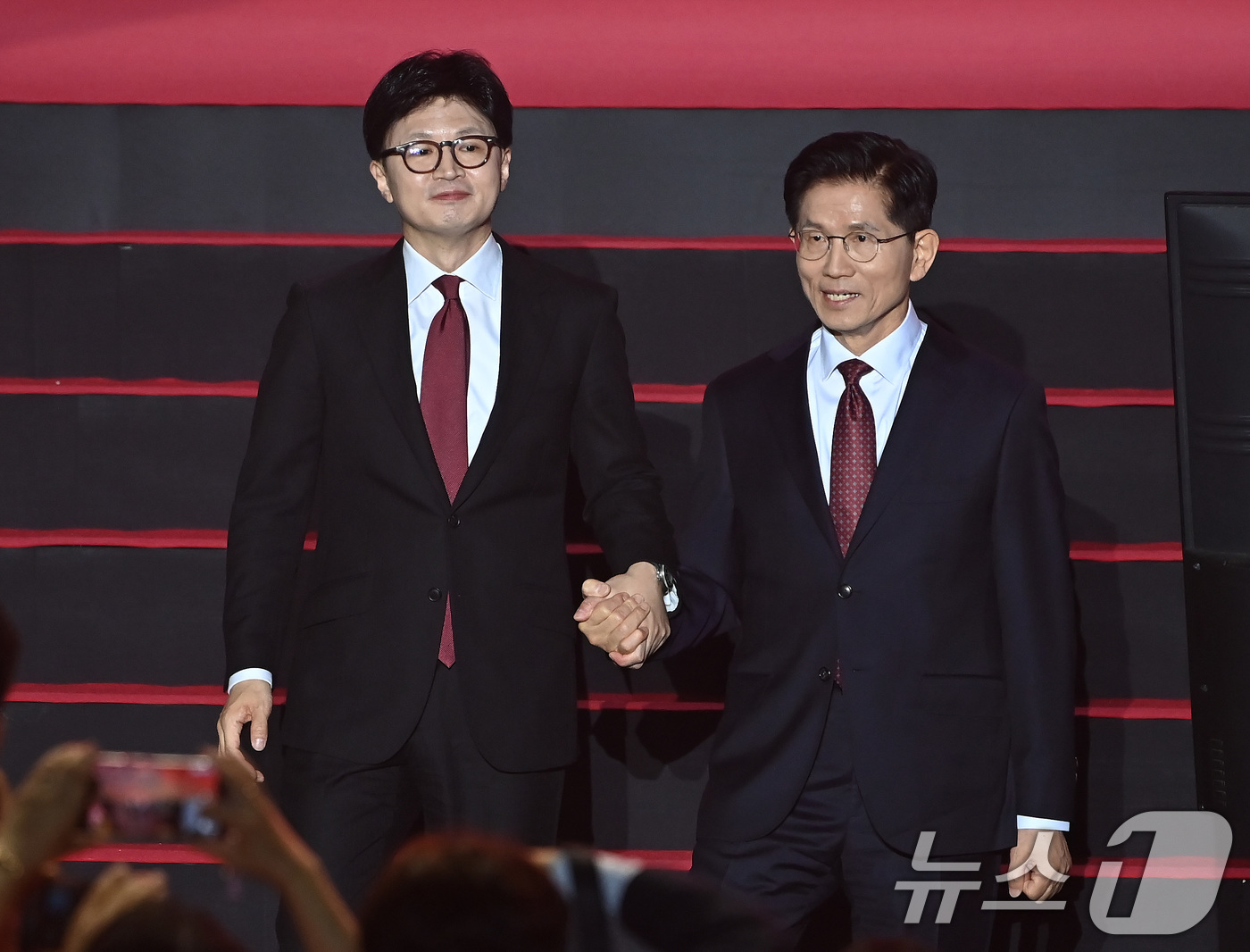 (고양=뉴스1) 이광호 기자 = 한동훈(왼쪽), 김문수 국민의힘 대선 경선 후보가 3일 경기 고양시 킨텍스에서 열린 5차 전당대회에서 손을 잡고 있다. (공동취재) 2025.5.3 …