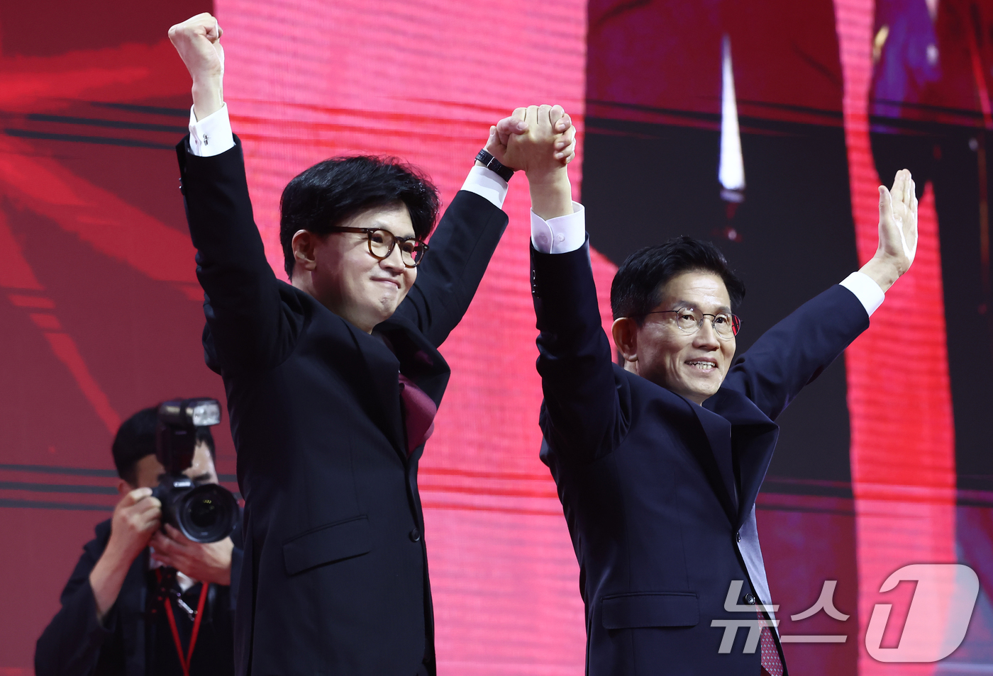 (고양=뉴스1) 김민지 기자 = 국민의힘 김문수, 한동훈 대선 경선 후보가 3일 경기 고양시 킨텍스에서 열린 5차 전당대회에서 손을 맞잡고 기념촬영을 하고 있다. 2025.5.3/ …