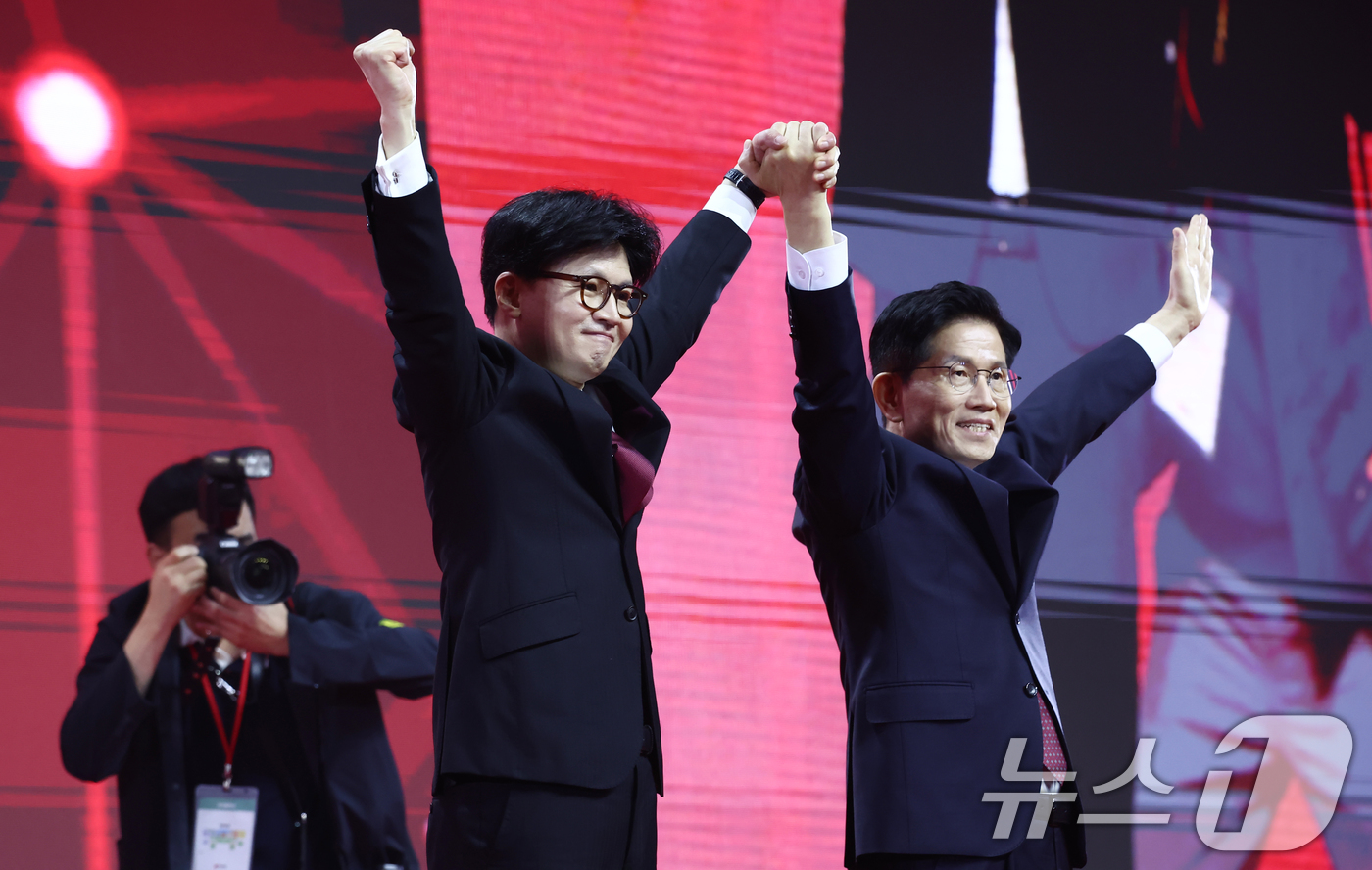 (고양=뉴스1) 김민지 기자 = 국민의힘 김문수, 한동훈 대선 경선 후보가 3일 경기 고양시 킨텍스에서 열린 5차 전당대회에서 손을 맞잡고 기념촬영을 하고 있다. 2025.5.3/ …