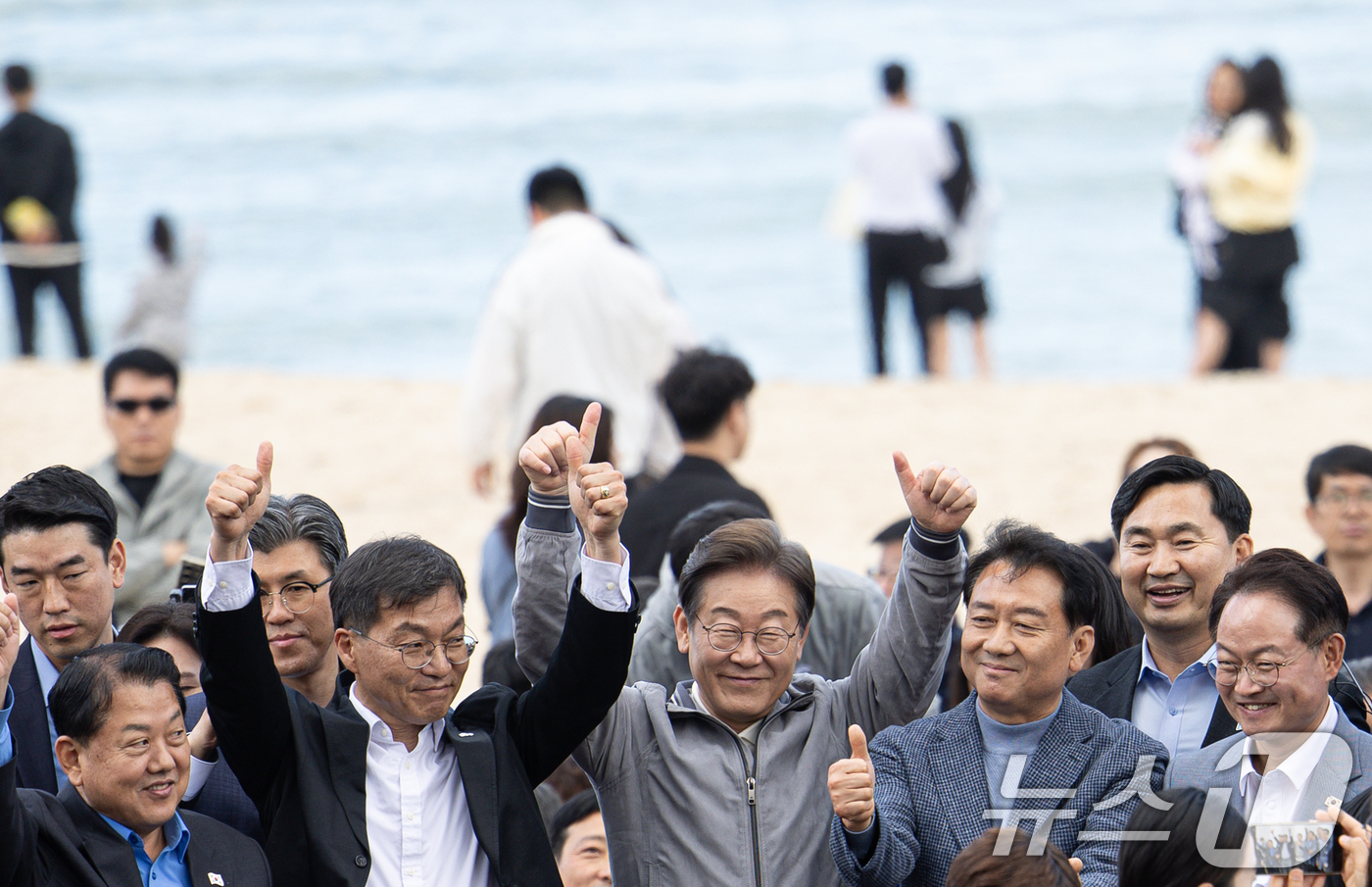 (강릉=뉴스1) 이재명 기자 = '골목골목 경청투어 : 동해안벨트편'에 나선 이재명 더불어민주당 대통령 후보가 3일 오후 강원 강릉시 안목해변에서 관계자들과 손을 들어보이고 있다. …