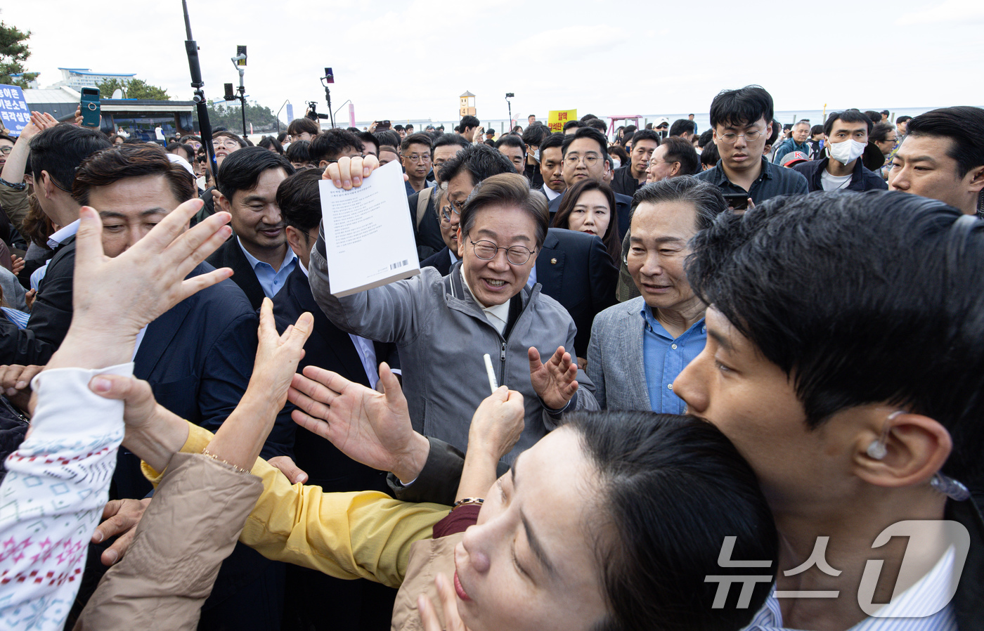 (삼척=뉴스1) 이재명 기자 = '골목골목 경청투어 : 동해안벨트편'에 나선 이재명 더불어민주당 대통령 후보가 3일 오후 강원 삼척시 삼척해수욕장에서 한 시민의 서명 요청에 응하고 …