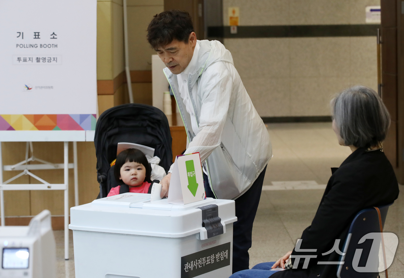 (부산=뉴스1) 윤일지 기자 = 제21대 대통령선거 사전투표 둘째 날인 30일 오전 부산 남구청 대강당에 마련된 사전투표소에서 유모차에 탄 아이가 아빠의 투표하는 모습을 지켜보고 …