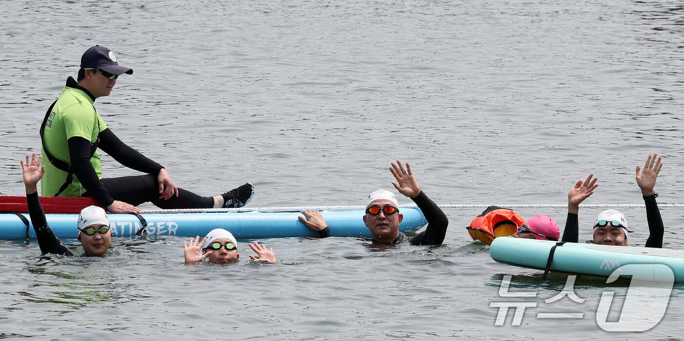 본문 이미지 - 오세훈 서울시장이 30일 오전 서울 송파구 잠실대교 남단에서 열린 제2회 쉬엄쉬엄 한강 3종 축제에 참여해 한강을 헤엄치다가 중간 쉼터인 모래톱 위에서 참가 시민들과 손을 흔들며 기념 촬영하고 있다. 2025.5.30/뉴스1 ⓒ News1 이동해 기자