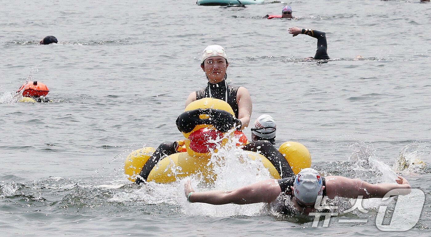 본문 이미지 - 30일 오전 서울 송파구 잠실대교 남단에서 열린 제2회 쉬엄쉬엄 한강 3종 축제 상급자코스 수영 1km 코스에서 한 참가자가 친구를 튜브에 채운 채 수영하고 있다. 2025.5.30/뉴스1 ⓒ News1 이동해 기자