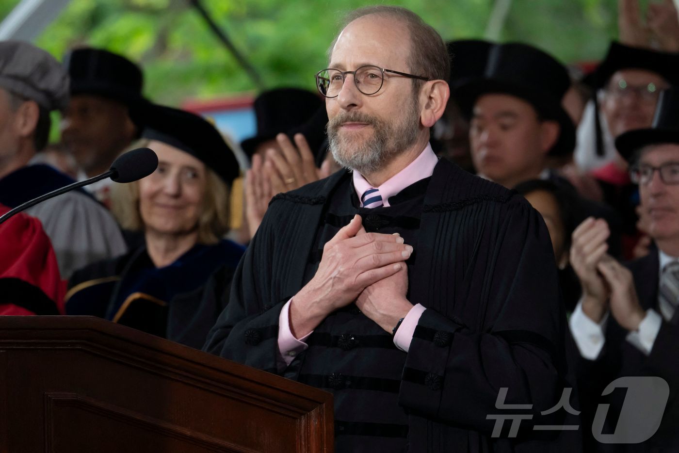 (케임브리지 AFP=뉴스1) 권영미 기자 = 앨런 가버 하버드대 총장이 28일(현지시간) 캠퍼스 중앙 광장인 하버드야드에서 열린 졸업식에서 연설하는 동안 가슴에 손을 얹고 있다. …