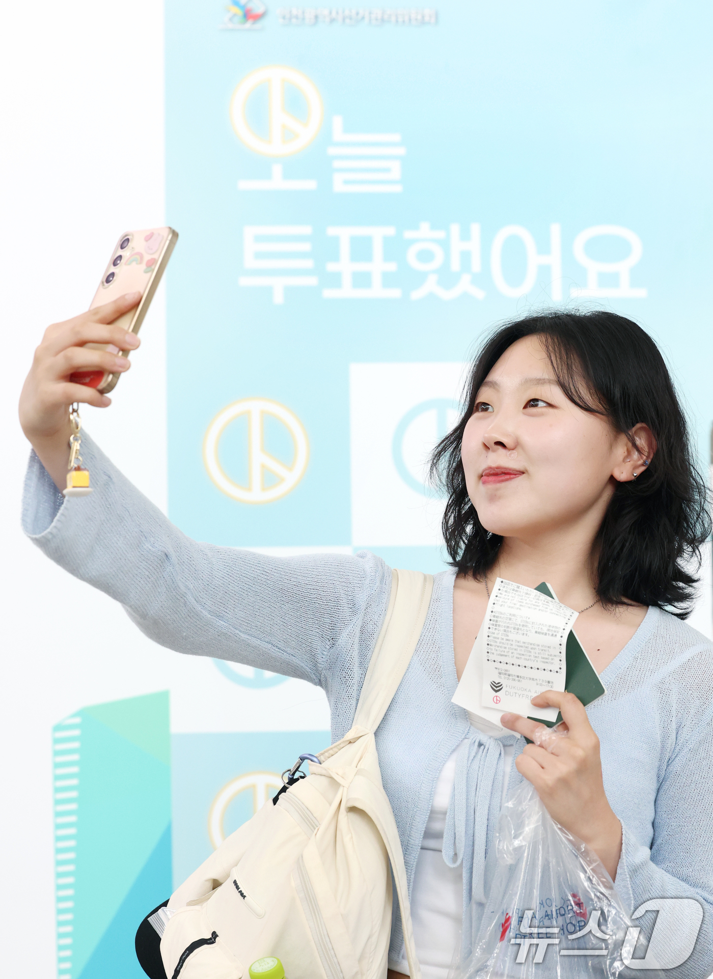 (인천공항=뉴스1) 권현진 기자 = 제21대 대통령선거 사전투표 둘째 날인 30일 인천공항국제공항에서 한 여행객이 투표를 마치고 인증샷을 찍고 있다. 2025.5.30/뉴스1