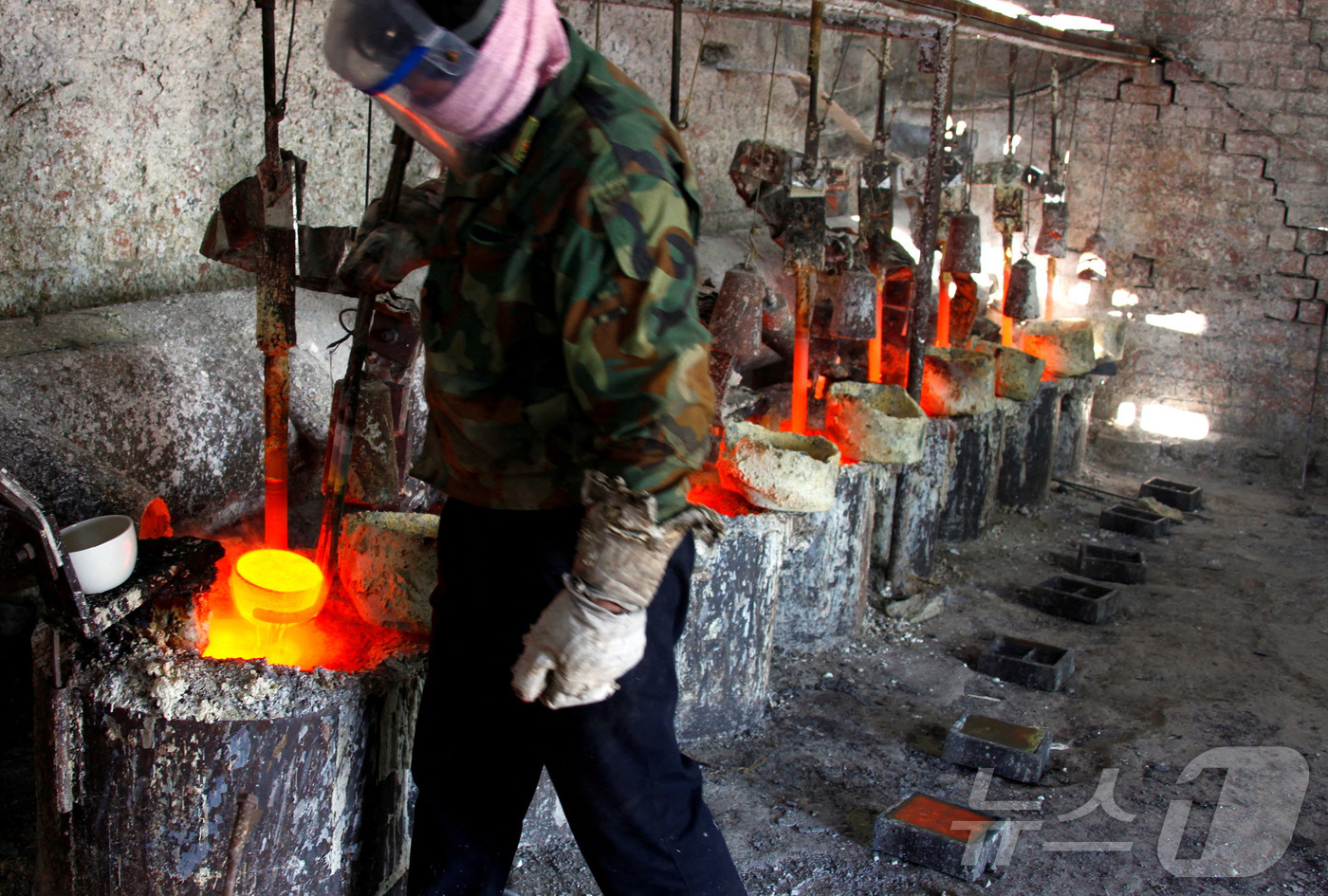 (다마오 로이터=뉴스1) 권영미 기자 = 중국 내몽골 자치구 다마오 마을 인근의 희토류 제련 공장에서 한 작업자가 희토류 금속 란타늄을 주형에 부을 준비를 하고 있다. 2010.1 …