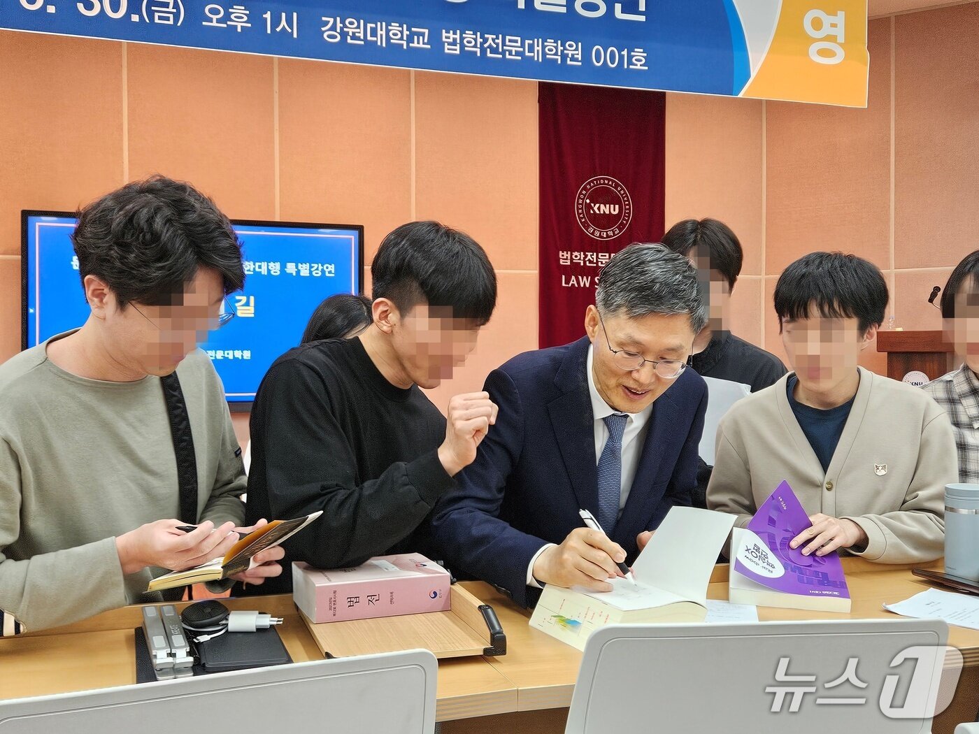 본문 이미지 -  문형배 전 헌법재판소장 권한대행이 30일 오후 강원대학교 법학전문대학원 대강당에서 재학생과 교직원들을 대상으로 &#39;법률가의 길&#39;을 주제로 특별강연을 끝낸 뒤 재학생의 사인 요청에 법전에 사인을 해주고 있다.2025..5.30 한귀섭 기자