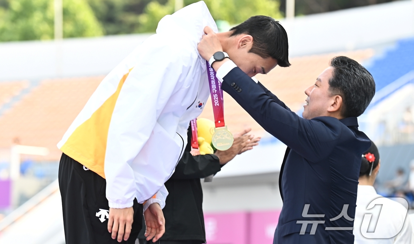 (구미=뉴스1) 정우용 기자 = 김장호 구미시장이 30일 아시아육상선수권 높이 뛰기 2연패를 달성한 '스마일 점퍼' 우상혁(29·용인시청)에게 금메달을 걸어주고 있다.우상혁은 전날 …