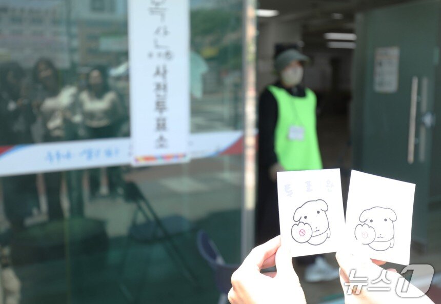 본문 이미지 - 30일 울산 중구 복산동 사전투표소에서 투표를 마친 유권자들이 인증 용지에 도장을 찍어 사진을 촬영하고 있다. 2025.5.30/뉴스1 ⓒ News1 김지혜 기자
