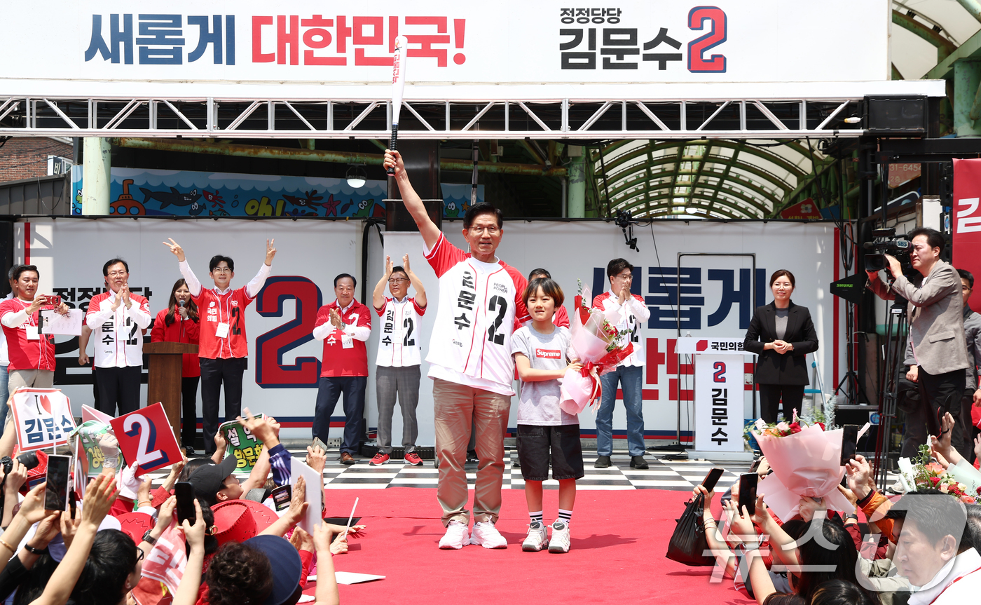 (속초=뉴스1) 김민지 기자 = 김문수 국민의힘 대통령 후보가 31일 강원 속초 관광수산시장에서 열린 속초시·인제군·고성군·양양군 합동유세에서 어린이에게 받은 야구 배트를 들어보이 …