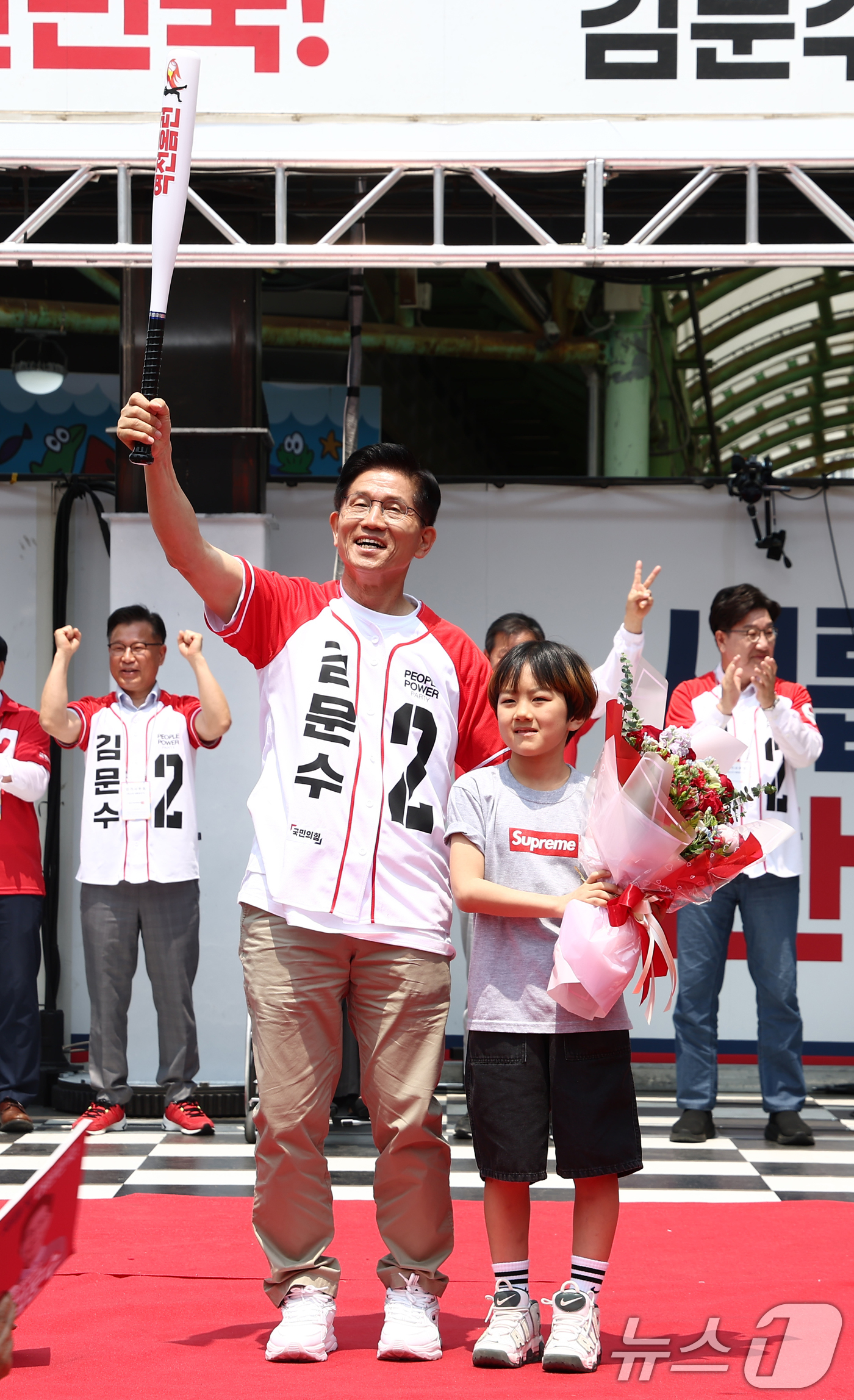 (속초=뉴스1) 김민지 기자 = 김문수 국민의힘 대통령 후보가 31일 강원 속초 관광수산시장에서 열린 속초시·인제군·고성군·양양군 합동유세에서 어린이에게 받은 야구 배트를 들어보이 …