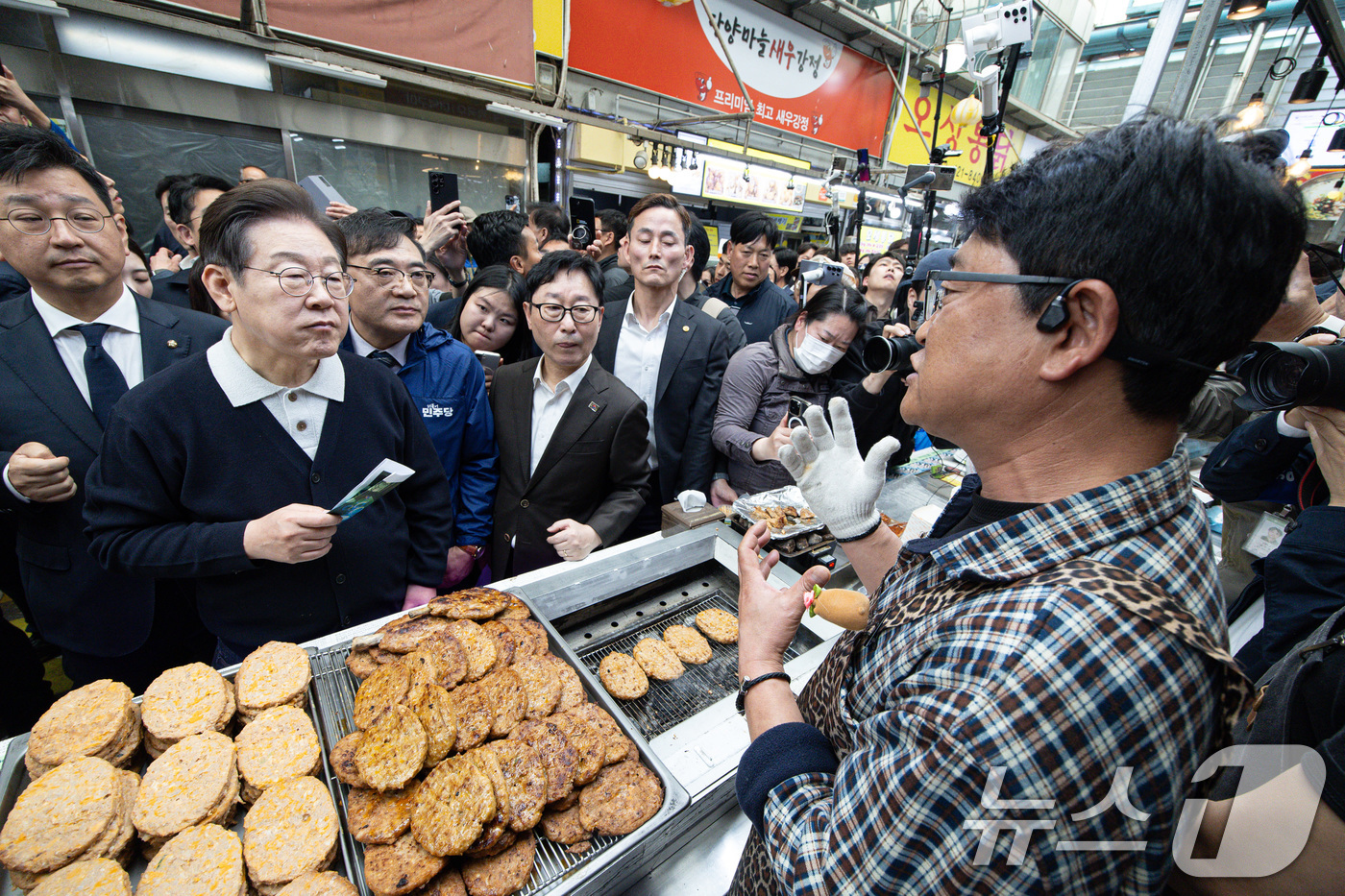 (단양=뉴스1) 이재명 기자 = '골목골목 경청투어 : 단양팔경편'에 나선 이재명 더불어민주당 대통령 후보가 4일 오전 충북 단양군 단양구경시장에서 떡갈비집 사장과 대화를 하고 있 …