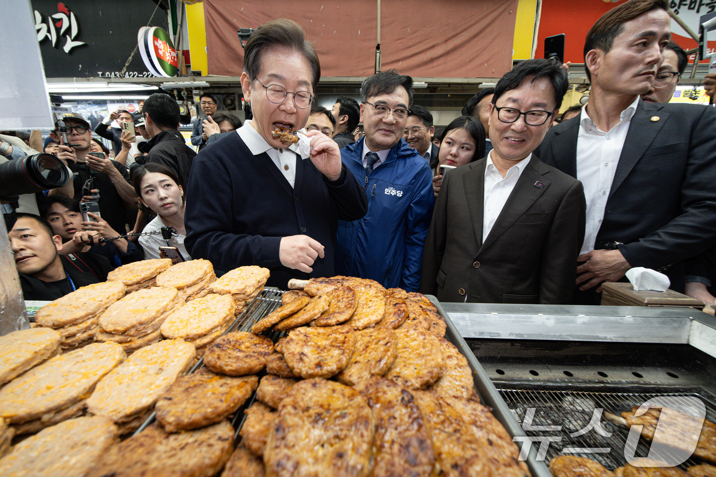 (단양=뉴스1) 이재명 기자 = '골목골목 경청투어 : 단양팔경편'에 나선 이재명 더불어민주당 대통령 후보가 4일 오전 충북 단양군 단양구경시장에서 떡갈비를 맛보고 있다. 2025 …