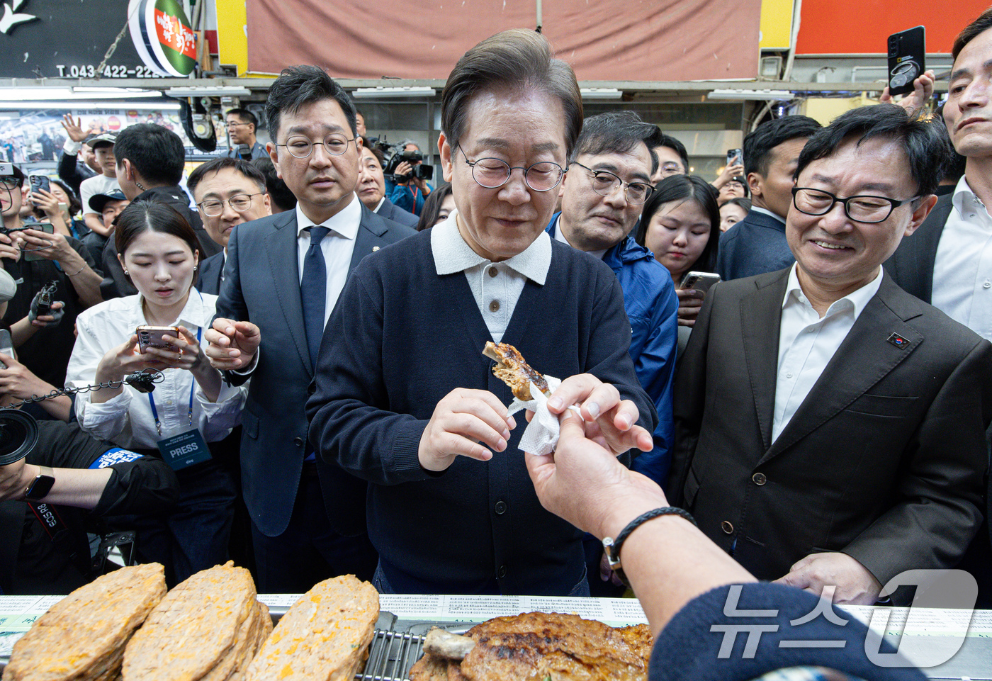 (단양=뉴스1) 이재명 기자 = '골목골목 경청투어 : 단양팔경편'에 나선 이재명 더불어민주당 대통령 후보가 4일 오전 충북 단양군 단양구경시장에서 떡갈비를 들어보이고 있다. 20 …