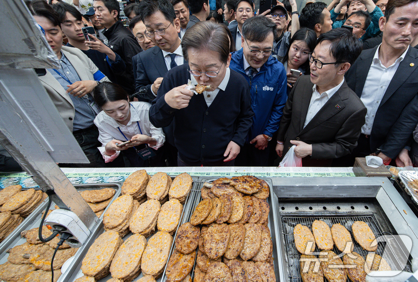(단양=뉴스1) 이재명 기자 = '골목골목 경청투어 : 단양팔경편'에 나선 이재명 더불어민주당 대통령 후보가 4일 오전 충북 단양군 단양구경시장에서 떡갈비를 맛보고 있다. 2025 …