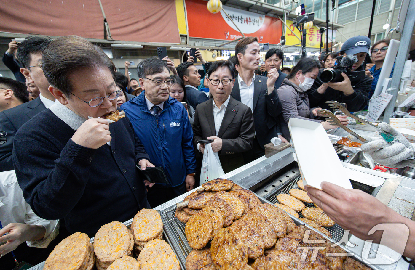 (단양=뉴스1) 이재명 기자 = '골목골목 경청투어 : 단양팔경편'에 나선 이재명 더불어민주당 대통령 후보가 4일 오전 충북 단양군 단양구경시장에서 떡갈비를 맛보고 있다. 2025 …