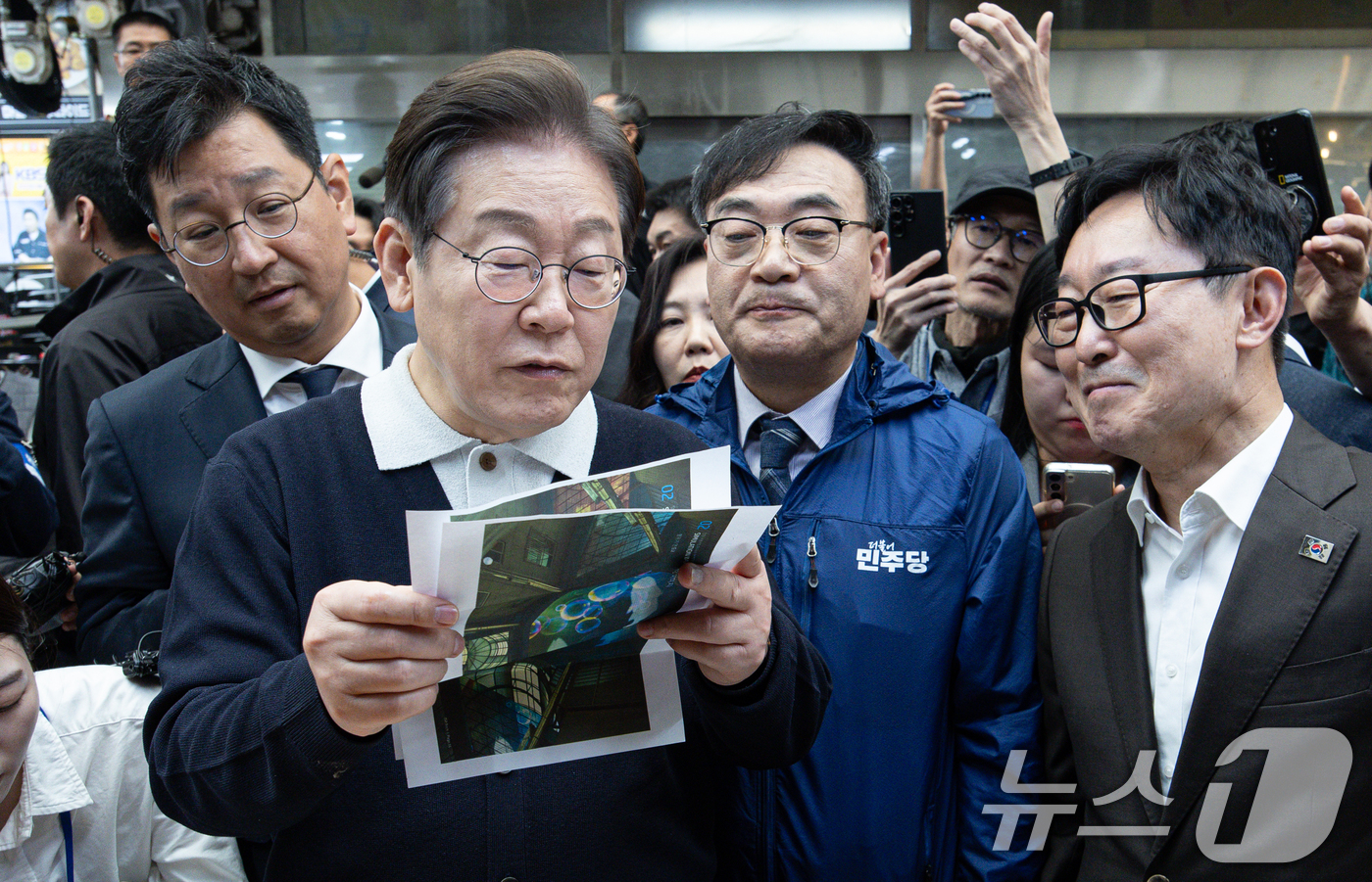 (단양=뉴스1) 이재명 기자 = '골목골목 경청투어 : 단양팔경편'에 나선 이재명 더불어민주당 대통령 후보가 4일 오전 충북 단양군 단양구경시장에서 상인이 건네 준 편지를 읽어보고 …