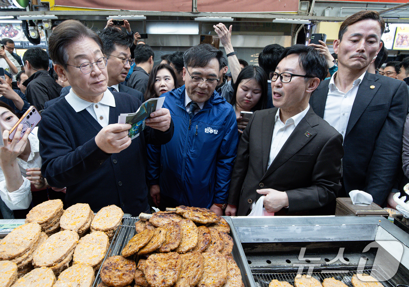 (단양=뉴스1) 이재명 기자 = '골목골목 경청투어 : 단양팔경편'에 나선 이재명 더불어민주당 대통령 후보가 4일 오전 충북 단양군 단양구경시장에서 상인이 건네 준 편지를 읽어보고 …