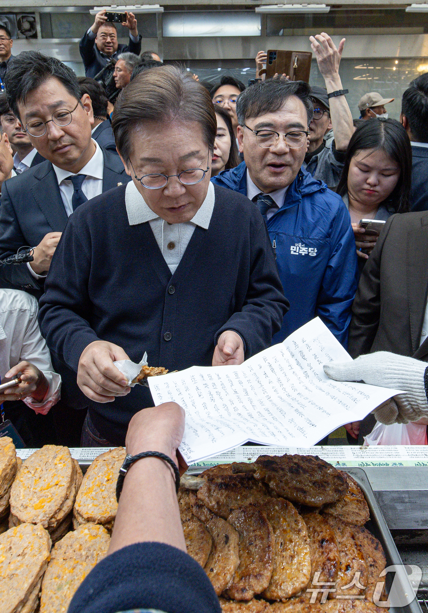 (단양=뉴스1) 이재명 기자 = '골목골목 경청투어 : 단양팔경편'에 나선 이재명 더불어민주당 대통령 후보가 4일 오전 충북 단양군 단양구경시장에서 상인이 건네는 편지를 받고 있다 …