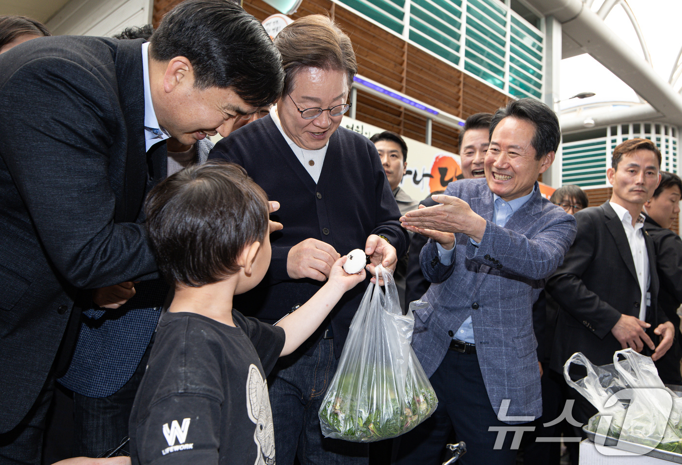 (영월=뉴스1) 이재명 기자 = '골목골목 경청투어 : 단양팔경편'에 나선 이재명 더불어민주당 대통령 후보가 4일 오후 강원 영월군 영월서부시장에서 한 어린이의 떡 선물을 받고 있 …