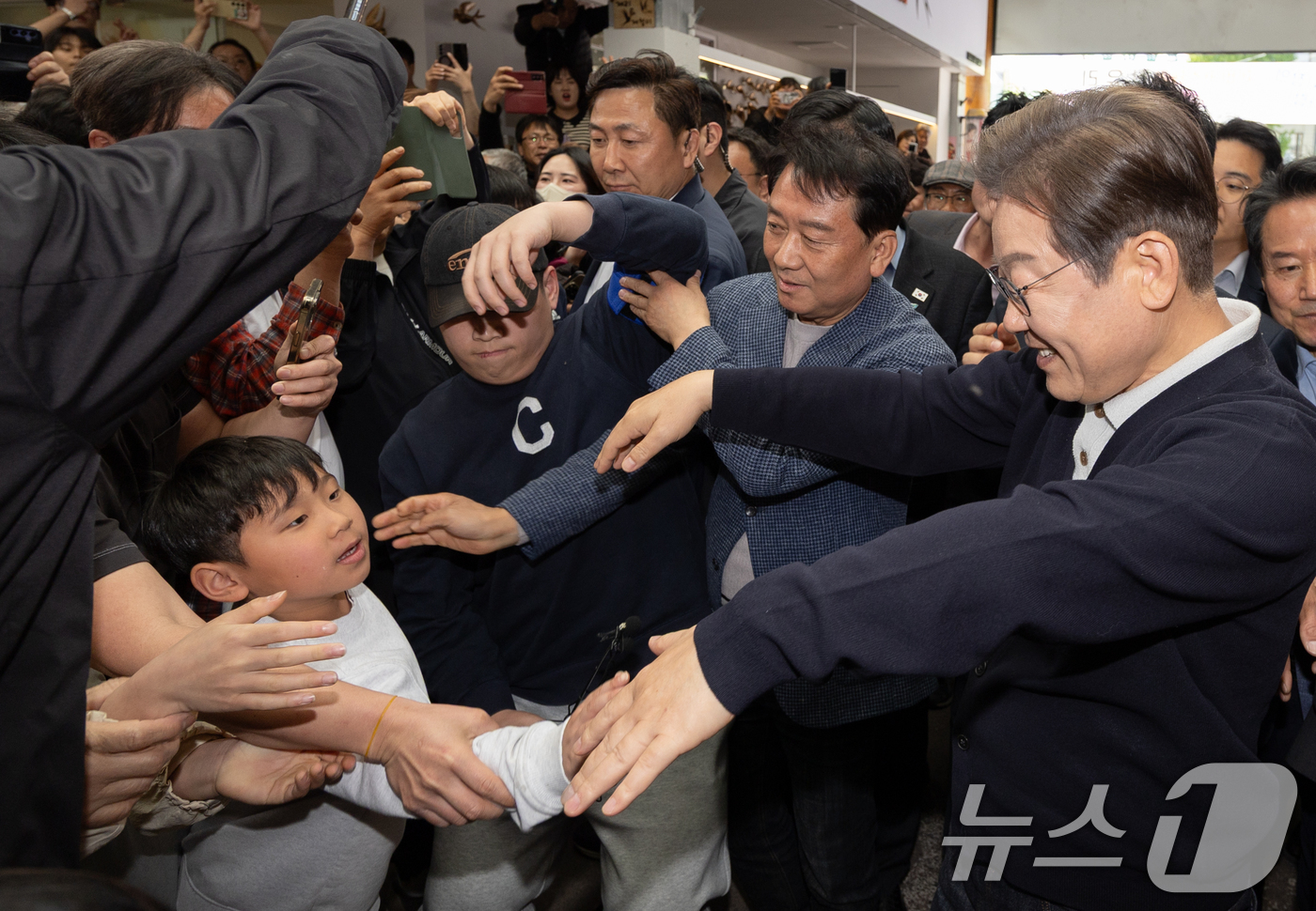 (영월=뉴스1) 이재명 기자 = '골목골목 경청투어 : 단양팔경편'에 나선 이재명 더불어민주당 대통령 후보가 4일 오후 강원 영월군 영월서부시장에서 한 어린이를 안아주고 있다. 2 …