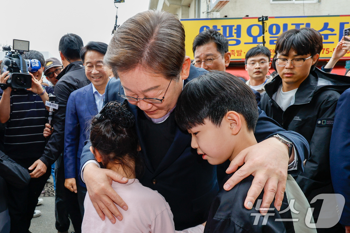 (양평=뉴스1) 안은나 기자 = 이재명 더불어민주당 대통령 후보가 2차 골목골목 경청투어에 나선 5일 오후 경기 양평군 양평시장의 문구점 앞에서 어린이들과 인사하고 있다. 2025 …