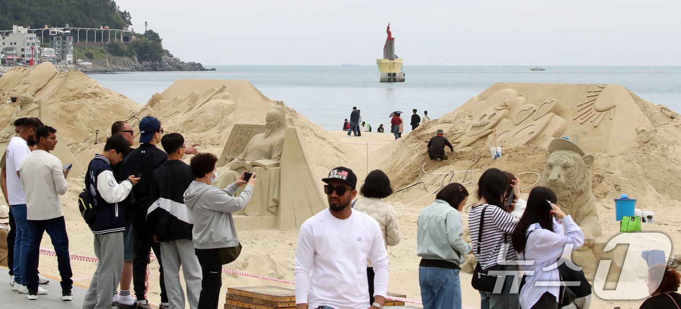 (부산=뉴스1) 윤일지 기자 = 어린이날인 5일 부산 해운대해수욕장을 찾은 시민, 관광객들이 다양한 모래조각 작품을 구경하고 있다.해운대구는 오는 16일부터 19일까지 '모래로 만 …