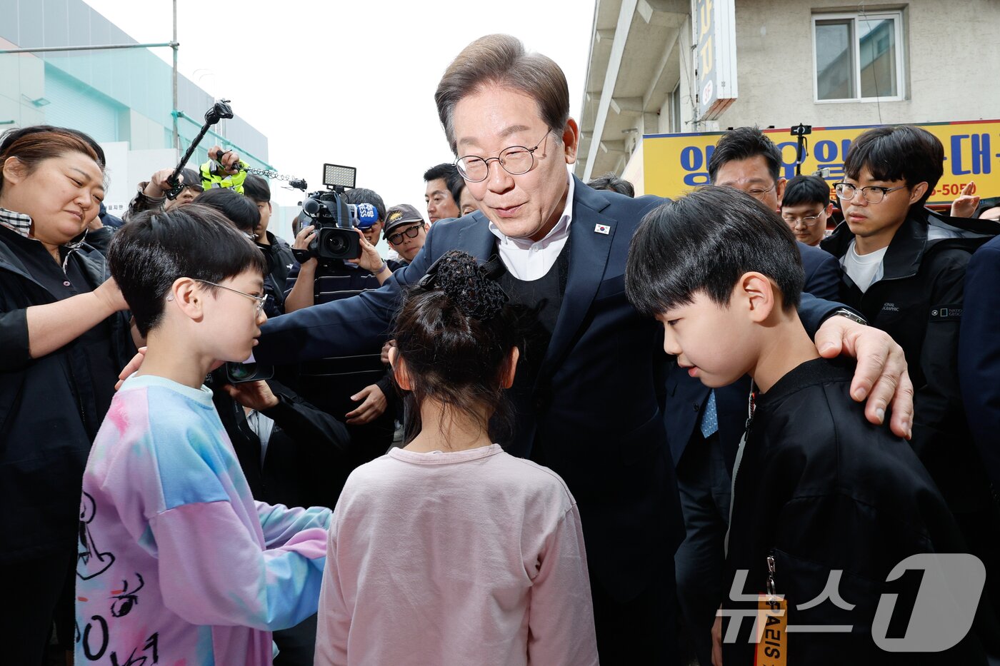 본문 이미지 - 이재명 더불어민주당 대통령 후보가 2차 골목골목 경청투어에 나선 5일 오후 경기 양평군 양평시장의 문구점 앞에서 어린이들과 인사하고 있다. 2025.5.5/뉴스1 ⓒ News1 안은나 기자