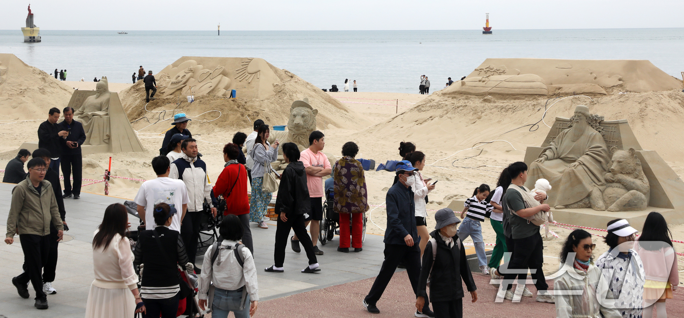 (부산=뉴스1) 윤일지 기자 = 어린이날인 5일 부산 해운대해수욕장을 찾은 시민, 관광객들이 다양한 모래조각 작품을 구경하고 있다.해운대구는 오는 16일부터 19일까지 '모래로 만 …