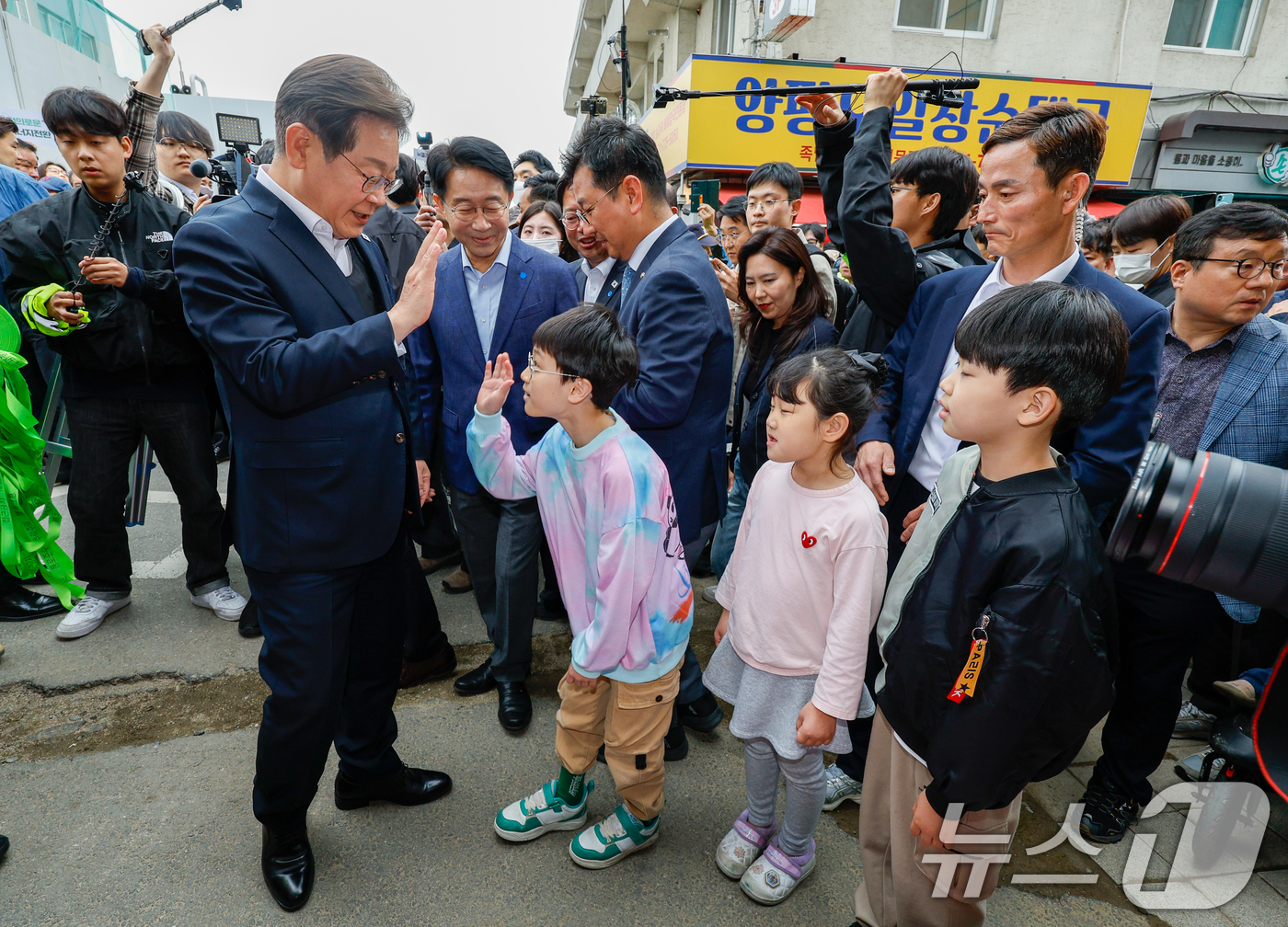 (양평=뉴스1) 안은나 기자 = 이재명 더불어민주당 대통령 후보가 2차 골목골목 경청투어에 나선 5일 오후 경기 양평군 양평시장의 문구점 앞에서 어린이들과 인사하고 있다. 2025 …