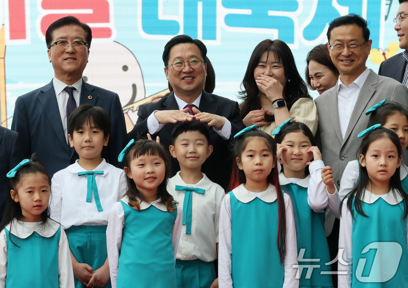 (대전=뉴스1) 김기태 기자 = 이장우 대전시장이 5일 대전 유성구 어린이회관에서 열린 제103주년 어린이날 기념행사에서 기념촬영에 앞서 비가 내리자 손으로 어린이 비를 막아주고 …