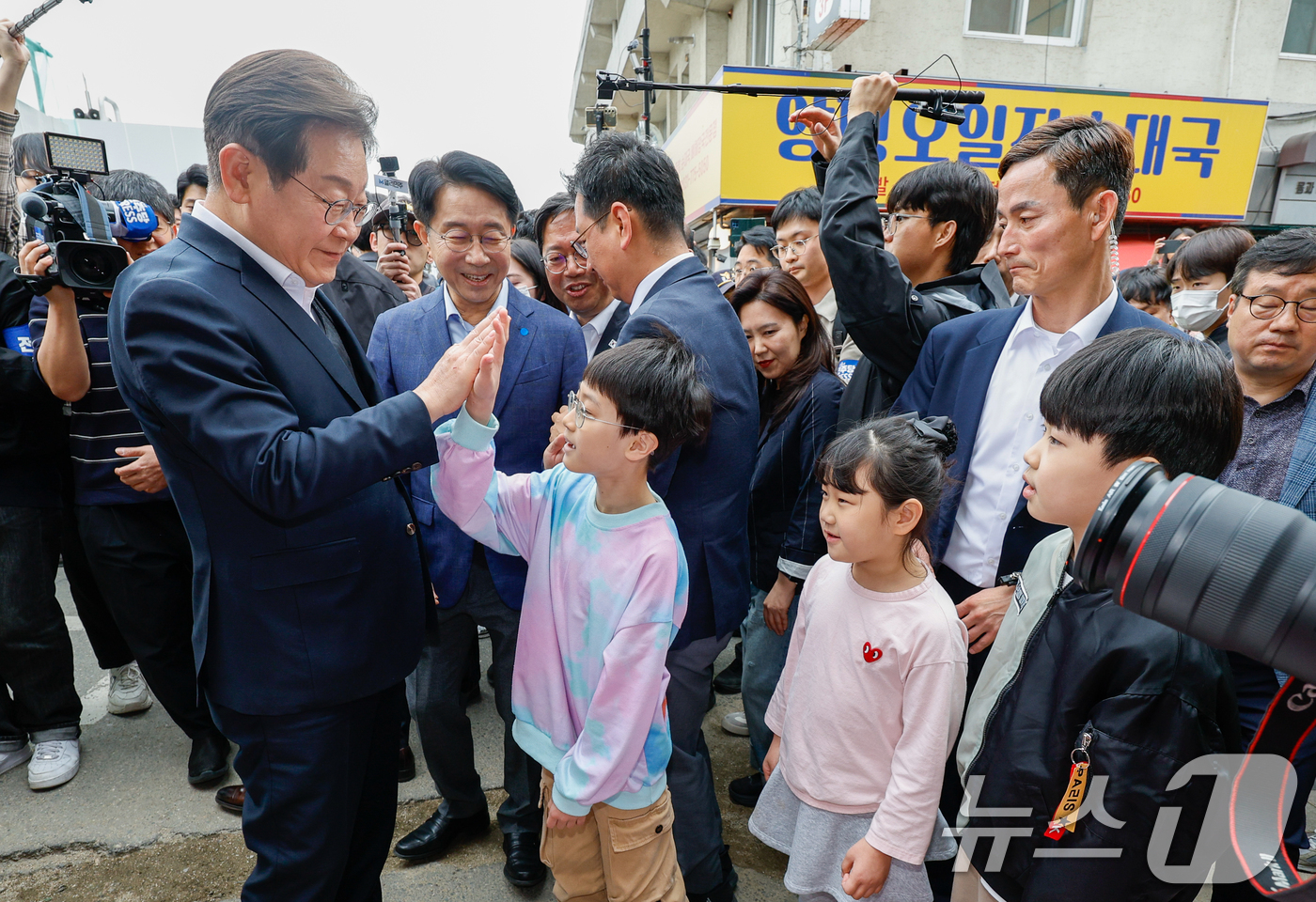 (양평=뉴스1) 안은나 기자 = 이재명 더불어민주당 대통령 후보가 2차 골목골목 경청투어에 나선 5일 오후 경기 양평군 양평시장의 문구점 앞에서 어린이들과 인사하고 있다. 2025 …