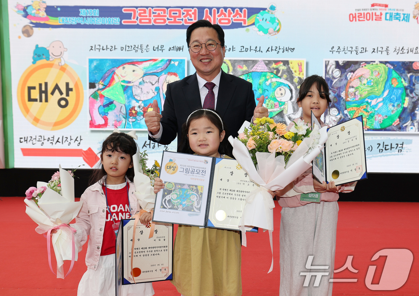 (대전=뉴스1) 김기태 기자 = 이장우 대전시장이 5일 대전 유성구 어린이회관에서 열린 제103주년 어린이날 기념행사에서 그림 공모전 수상자와 포즈를 취하고 있다.  2025.5. …