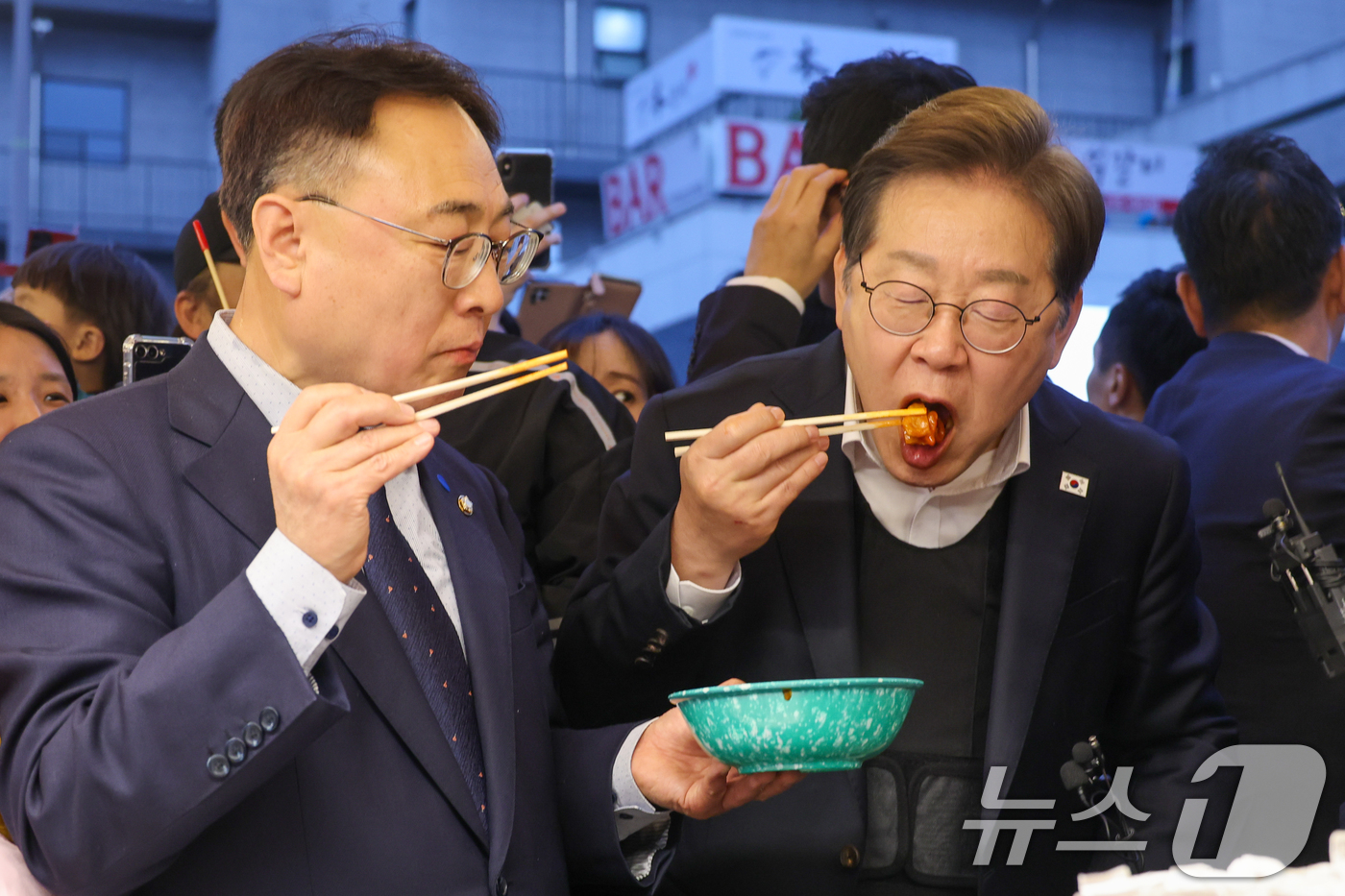 (진천=뉴스1) 안은나 기자 = 이재명 더불어민주당 대통령 후보가 2차 골목골목 경청투어에 나선 5일 오후 충북 진천군의 혁신도시 상가를 찾아 떡볶이를 먹고 있다. 2025.5.5 …