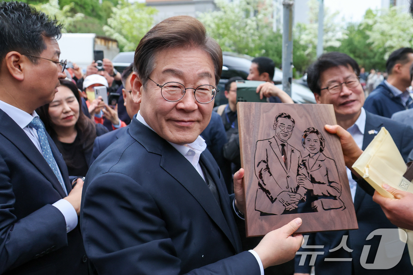 (진천=뉴스1) 안은나 기자 = 이재명 더불어민주당 대통령 후보가 2차 골목골목 경청투어에 나선 5일 오후 충북 진천군의 혁신도시 상가를 찾아 한 시민으로부터 이 후보와 김혜경 여 …