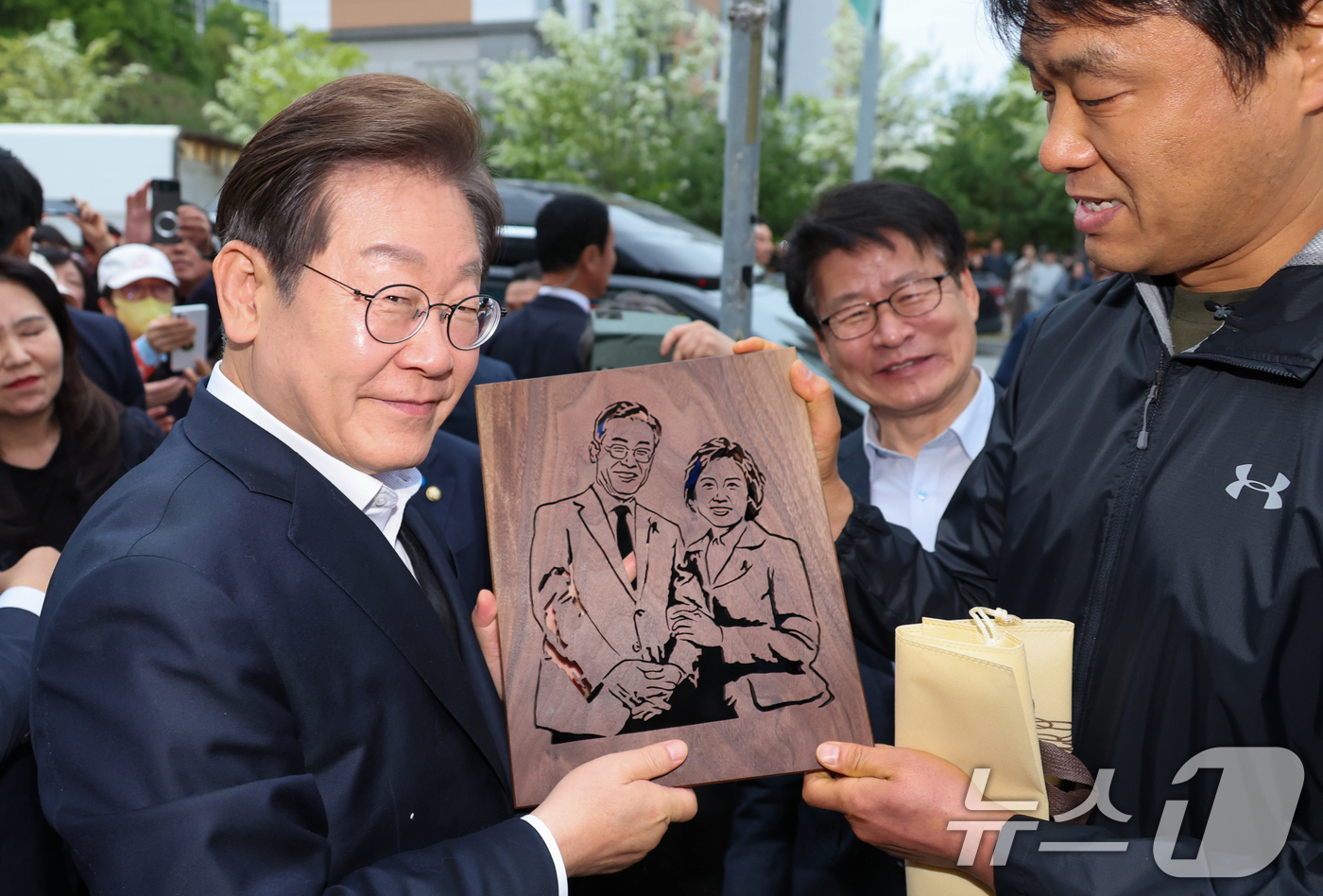 (진천=뉴스1) 안은나 기자 = 이재명 더불어민주당 대통령 후보가 2차 골목골목 경청투어에 나선 5일 오후 충북 진천군의 혁신도시 상가를 찾아 한 시민으로부터 이 후보와 김혜경 여 …