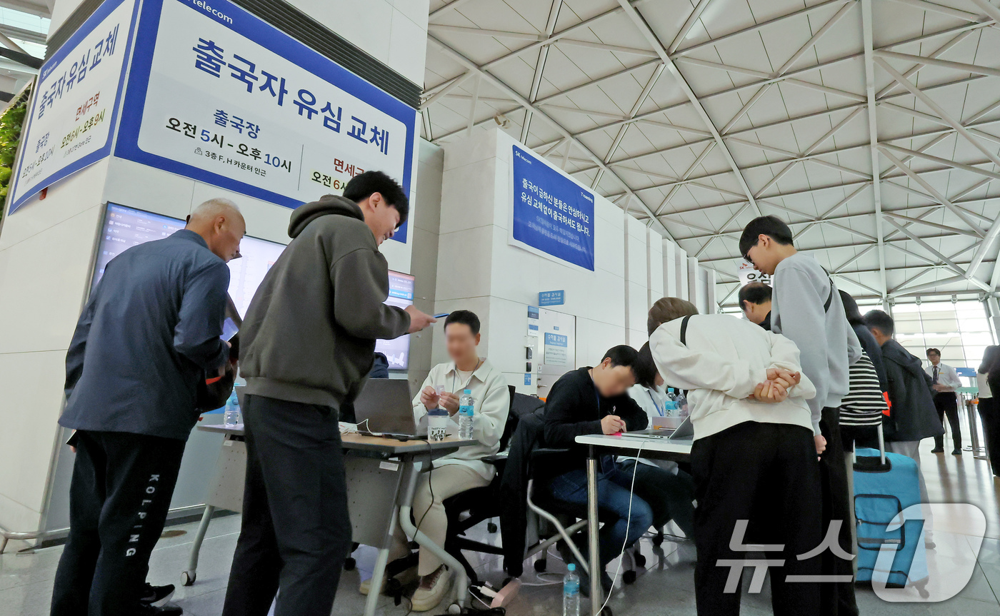 (인천공항=뉴스1) 장수영 기자 = 6일 오전 인천국제공항에 설치된 SKT 부스를 찾은 여행객들이 출국에 앞서 유심을 교체하고 있다. 2025.5.6/뉴스1