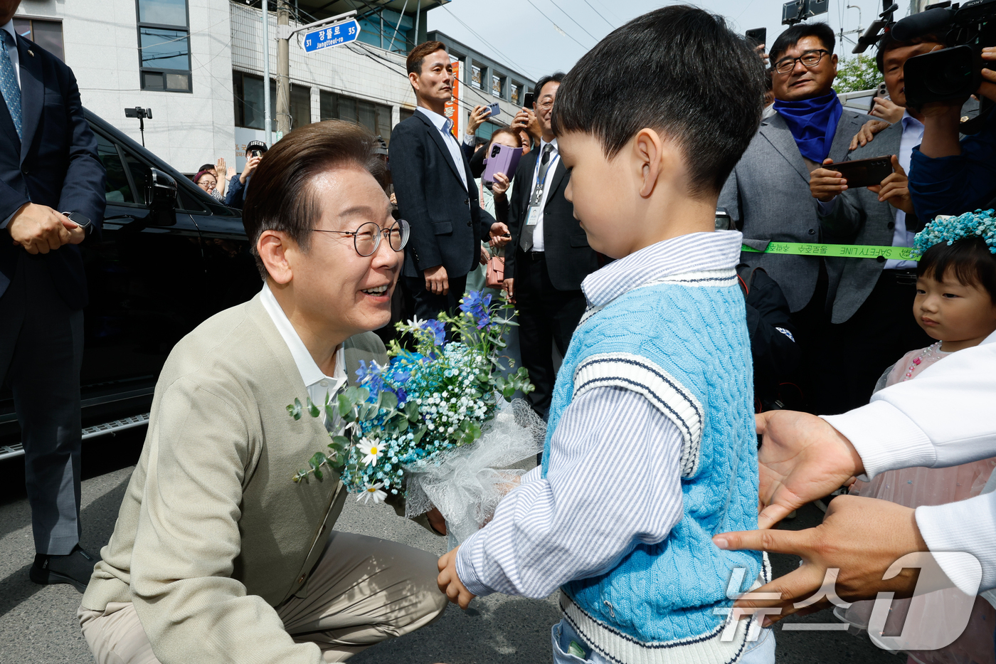 (증평=뉴스1) 안은나 기자 = 이재명 더불어민주당 대통령 후보가 6일 오전 골목골목 경청투어를 위해 충북 증평군 장뜰시장에 도착, 어린이로부터 꽃다발을 받고 있다. 2025.5. …