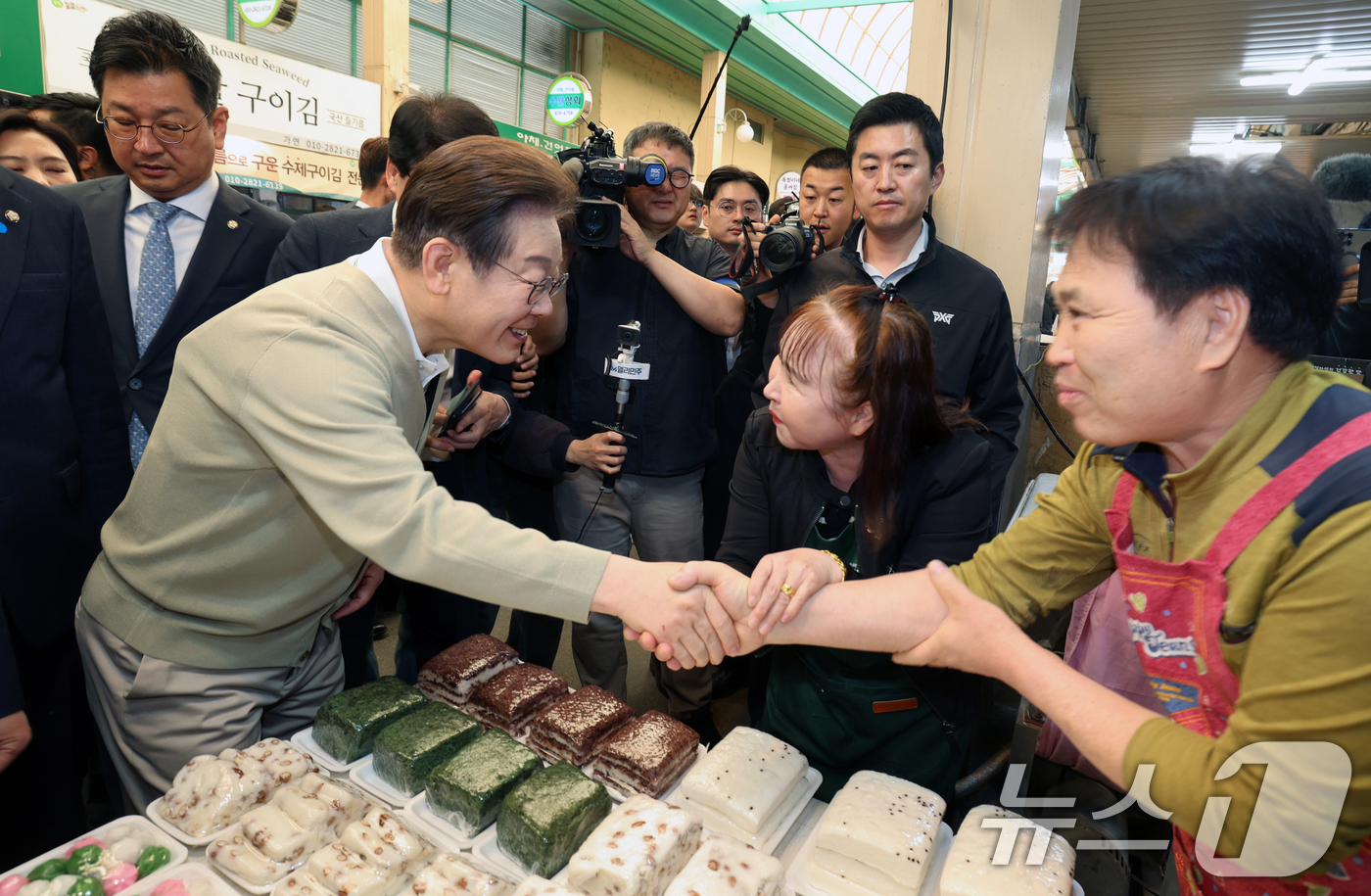 (증평=뉴스1) 안은나 기자 = 이재명 더불어민주당 대통령 후보가 골목골목 경청투어 이틀차를 맞은 6일 오전 충북 증평군 장뜰시장을 찾아 떡집 상인과 악수하고 있다. (공동취재) …