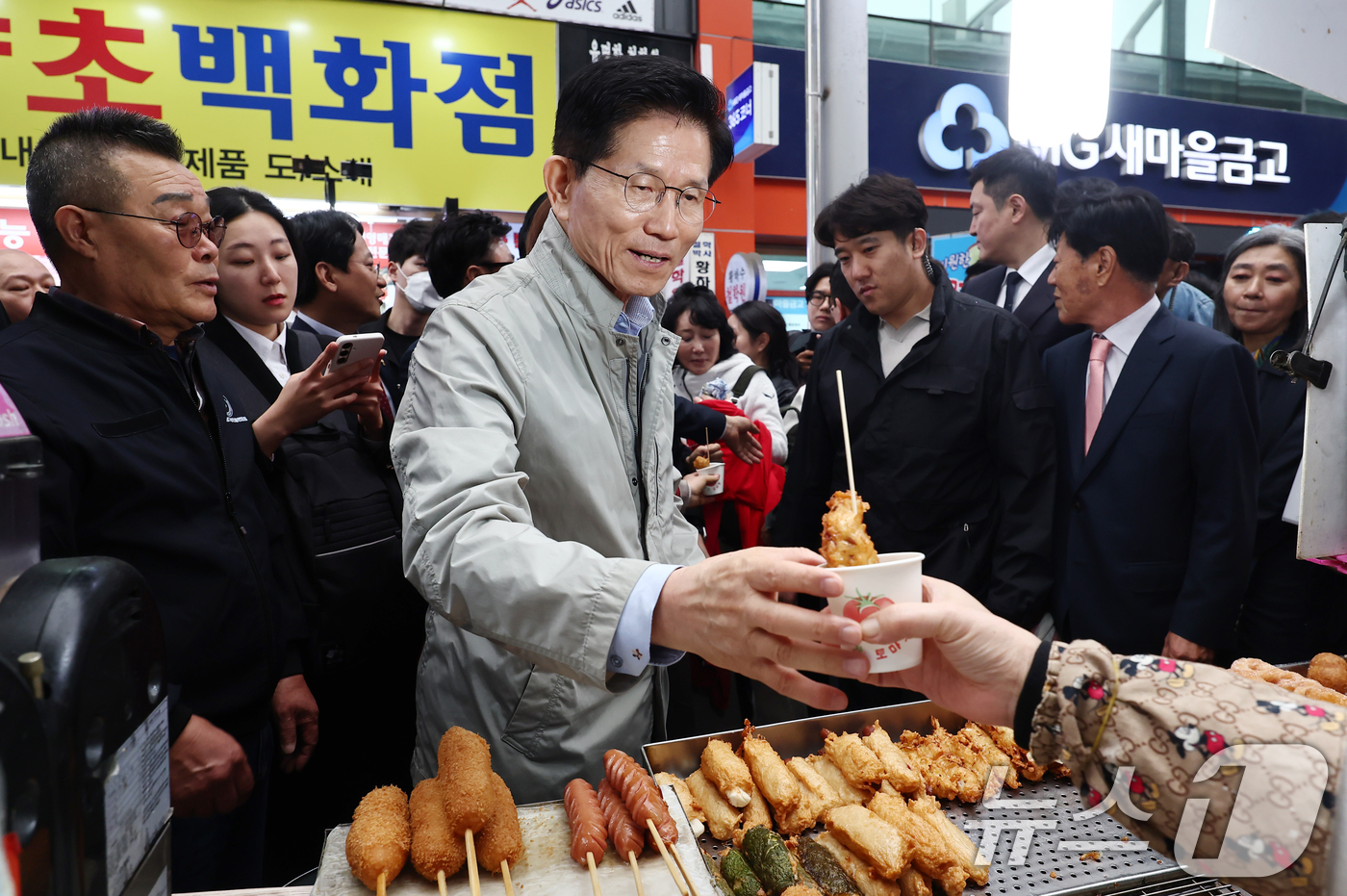 (포항=뉴스1) 김민지 기자 = 김문수 국민의힘 대통령 후보가 6일 경북 포항시 죽도시장을 방문해 어묵을 구매하고 있다. 2025.5.6/뉴스1