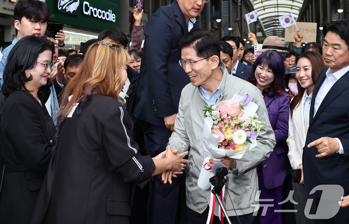 (포항=뉴스1) 김민지 기자 = 김문수 국민의힘 대통령 후보가 6일 경북 포항시 죽도시장에서 지지자들에게 꽃다발을 받고 있다. 2025.5.6/뉴스1