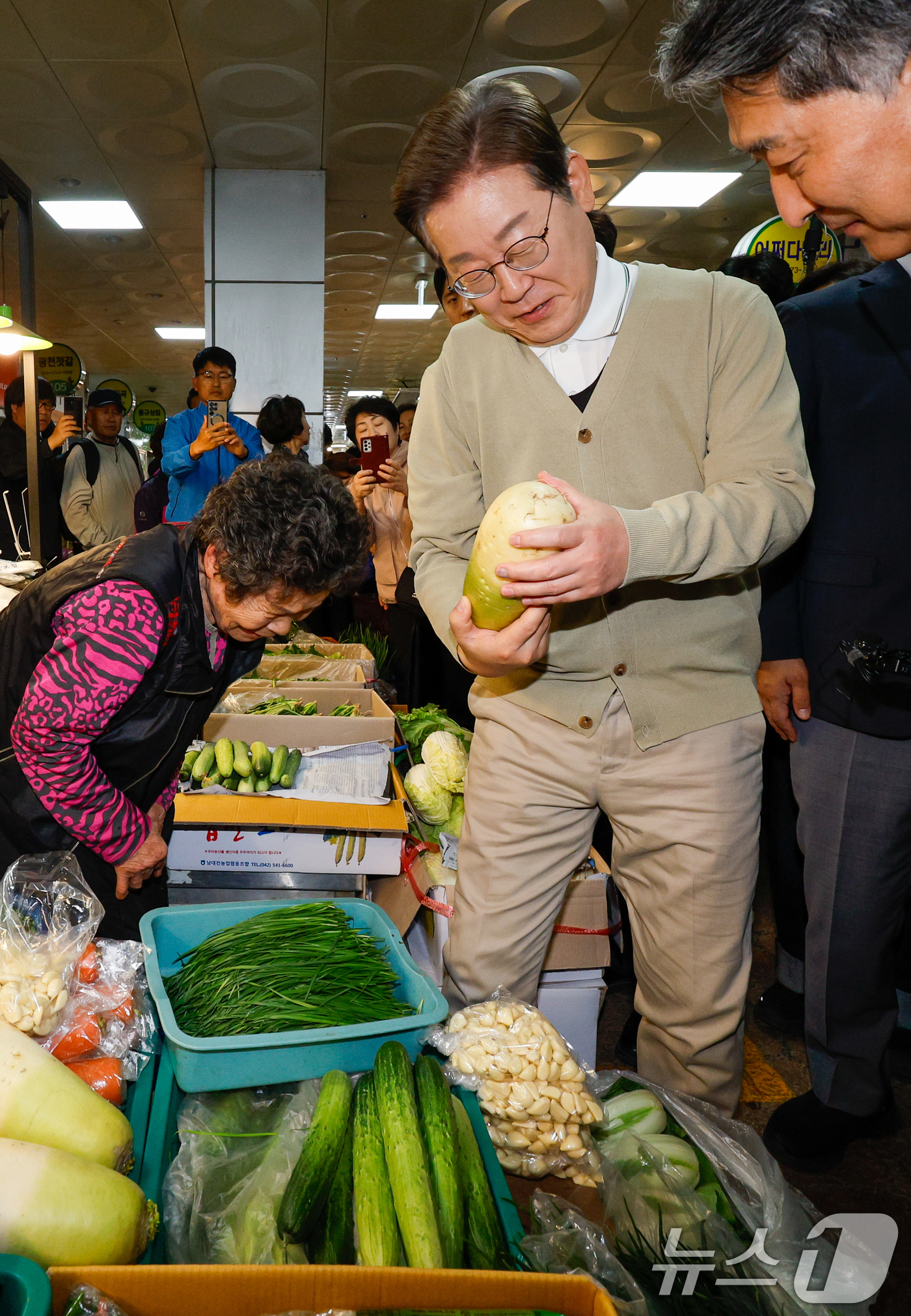 (옥천=뉴스1) 안은나 기자 = 이재명 더불어민주당 대통령 후보가 골목골목 경청투어 이틀차인 6일 오후 충북 옥천군 공설시장을 찾아 무를 구입하고 있다. 2025.5.6/뉴스1