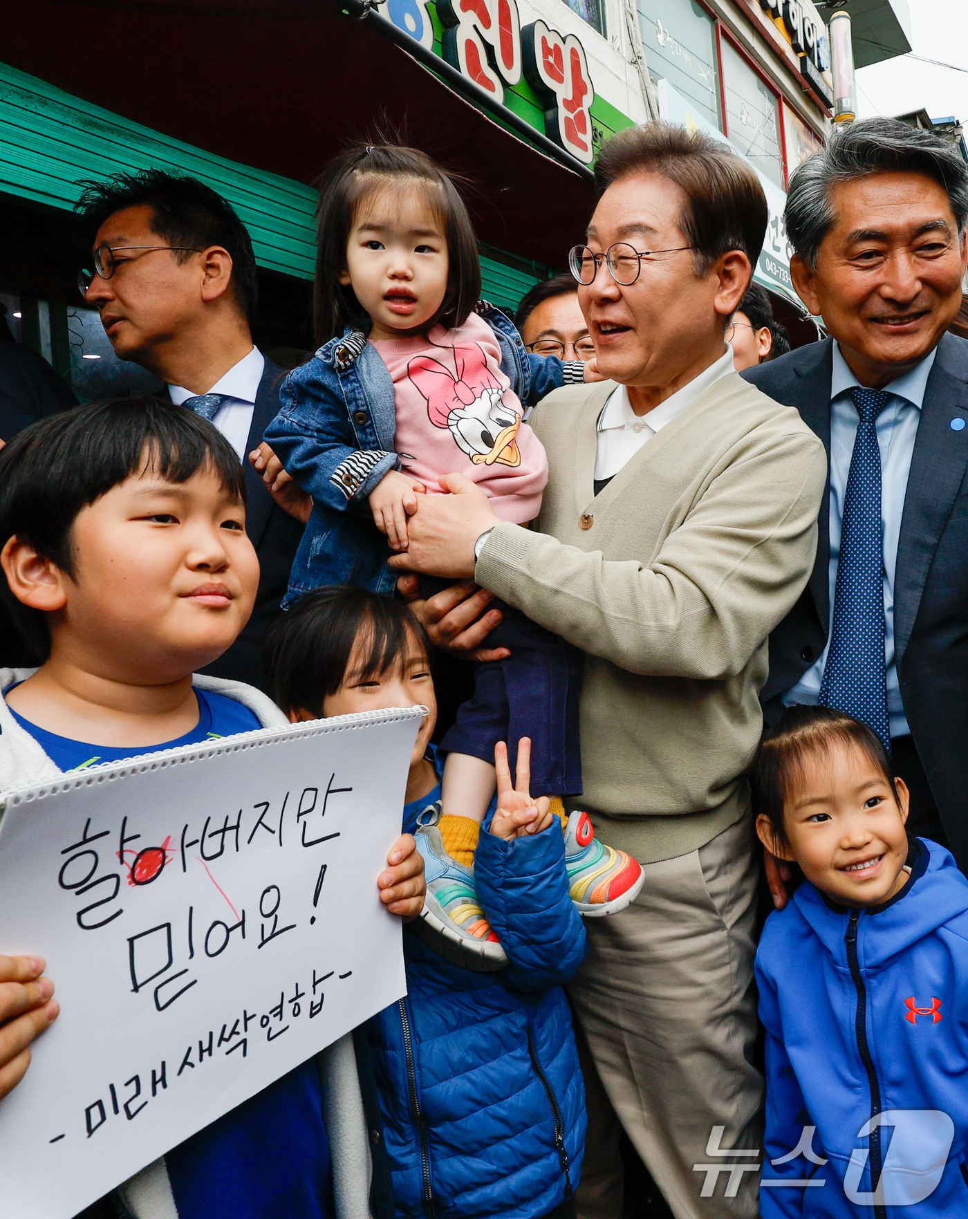 (옥천=뉴스1) 안은나 기자 = 이재명 더불어민주당 대통령 후보가 골목골목 경청투어 이틀차인 6일 오후 충북 옥천군 공설시장을 찾아 어린이들과 기념 촬영하고 있다. 2025.5.6 …