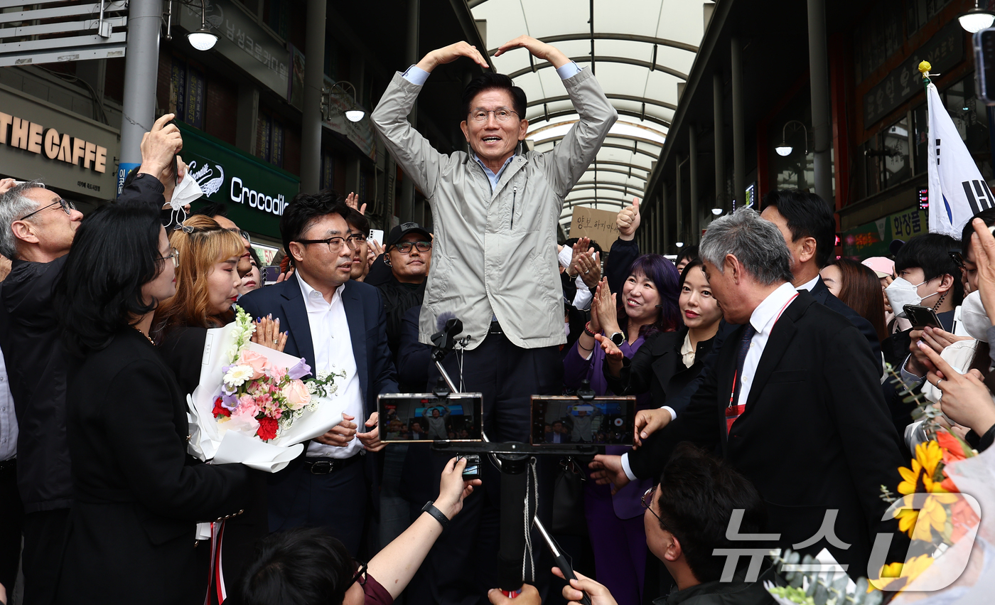 (포항=뉴스1) 김민지 기자 = 김문수 국민의힘 대통령 후보가 6일 경북 포항시 죽도시장에서 시민들과 인사하며 손하트를 그리고 있다. 2025.5.6/뉴스1