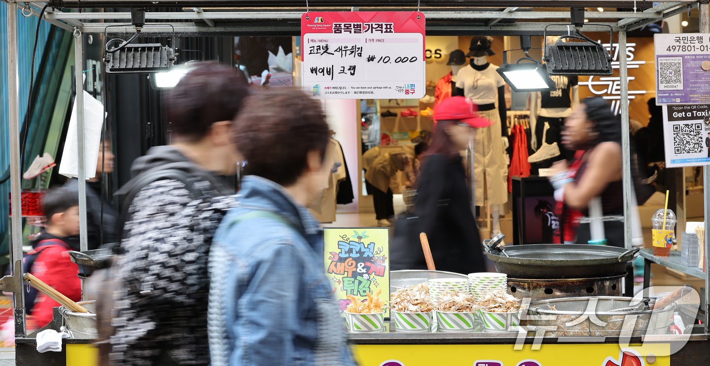 (서울=뉴스1) 장수영 기자 = 6일 서울 중구 명동거리를 찾은 관광객들이 거리에서 판매 중인 음식 앞으로 지나고 있다.통계청 소비자물가동향에 따르면 지난달 외식물가는 3.2% 상 …