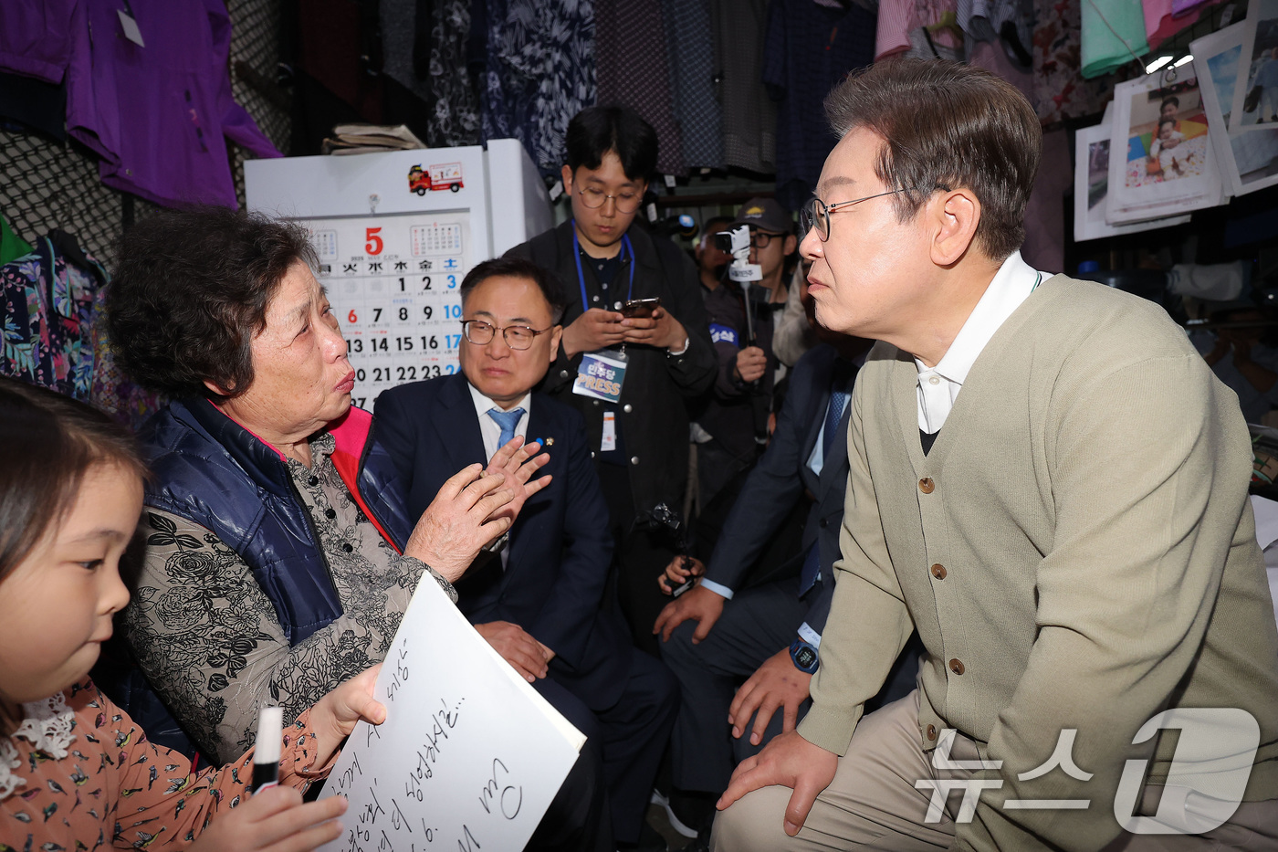 (옥천=뉴스1) 안은나 기자 = 이재명 더불어민주당 대통령 후보가 '골목골목 경청투어' : 국토종주편'에 나선 6일 충북 옥천군 옥천공설시장의 '국민보도연맹' 사건 피해자의 유가족 …