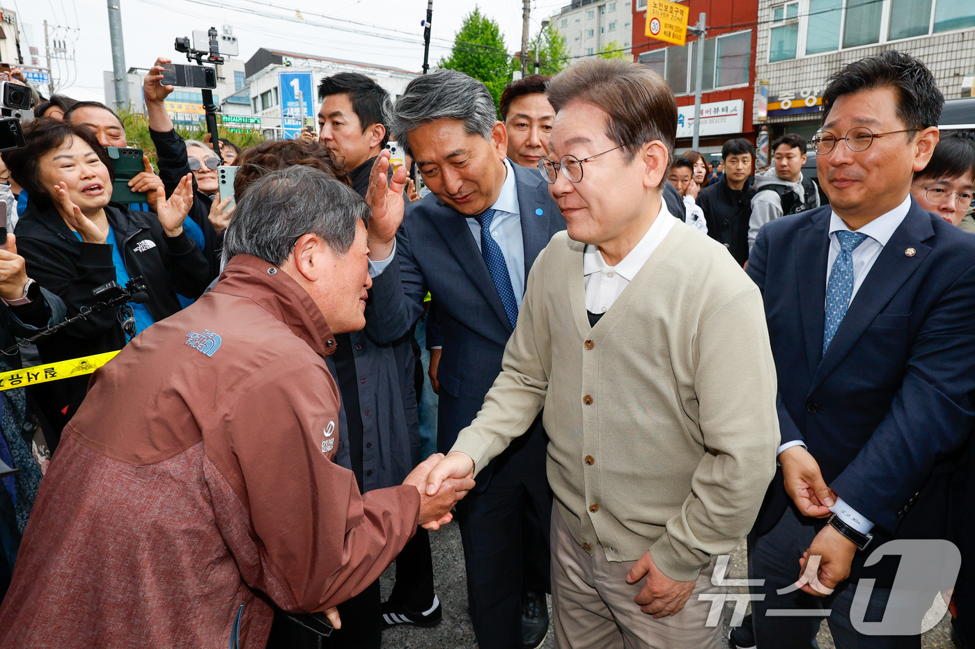 (옥천=뉴스1) 안은나 기자 = 이재명 더불어민주당 대통령 후보가 골목골목 경청투어 이틀차인 6일 오후 충북 옥천군 공설시장을 찾아 '옥천합동장의사’ 박종호 씨와 인사하고 있다. …