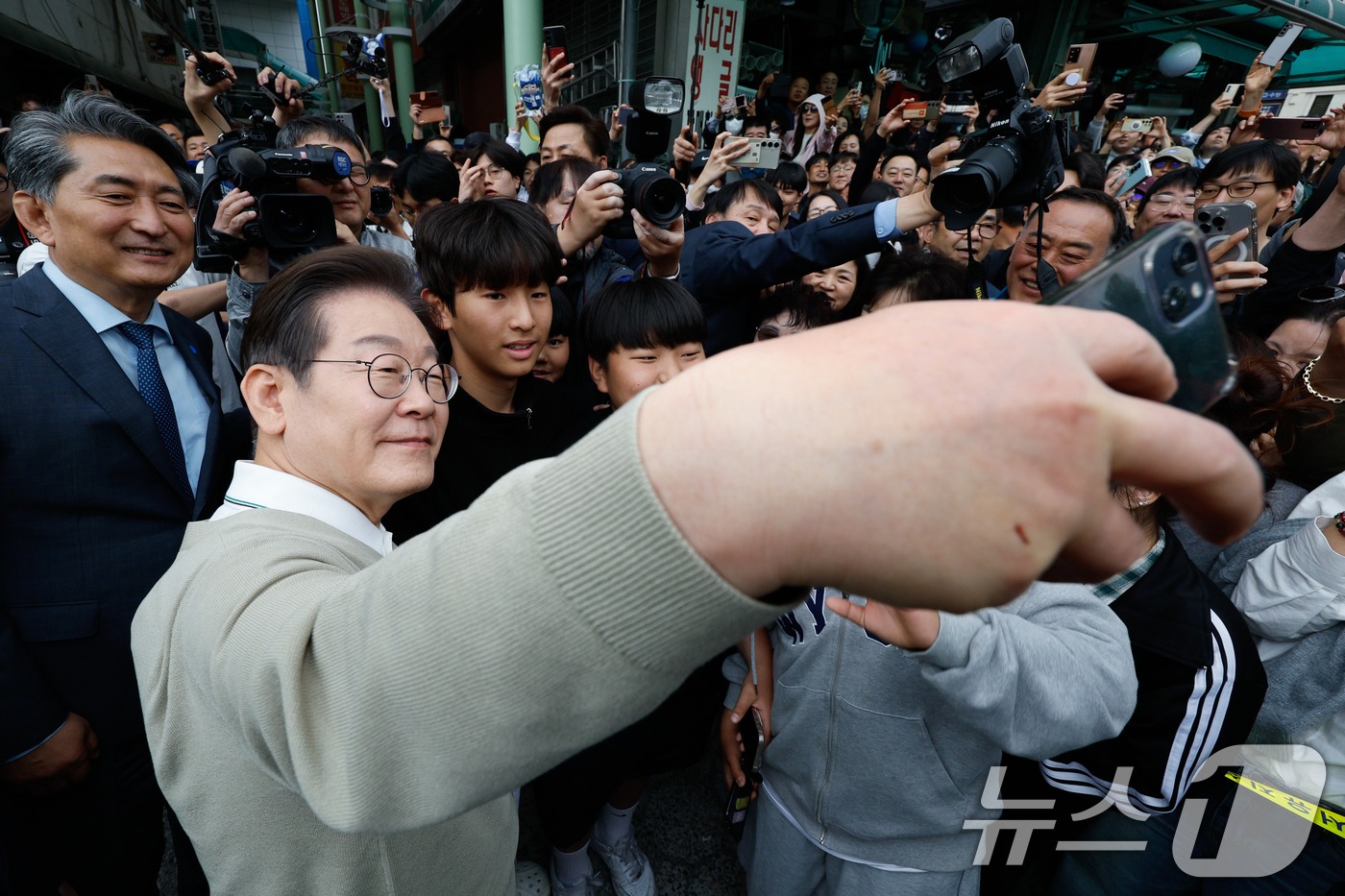 (옥천=뉴스1) 안은나 기자 = 이재명 더불어민주당 대통령 후보가 골목골목 경청투어 이틀차인 6일 오후 충북 옥천군 공설시장을 찾아 어린이들과 셀카를 찍고 있다. 2025.5.6/ …